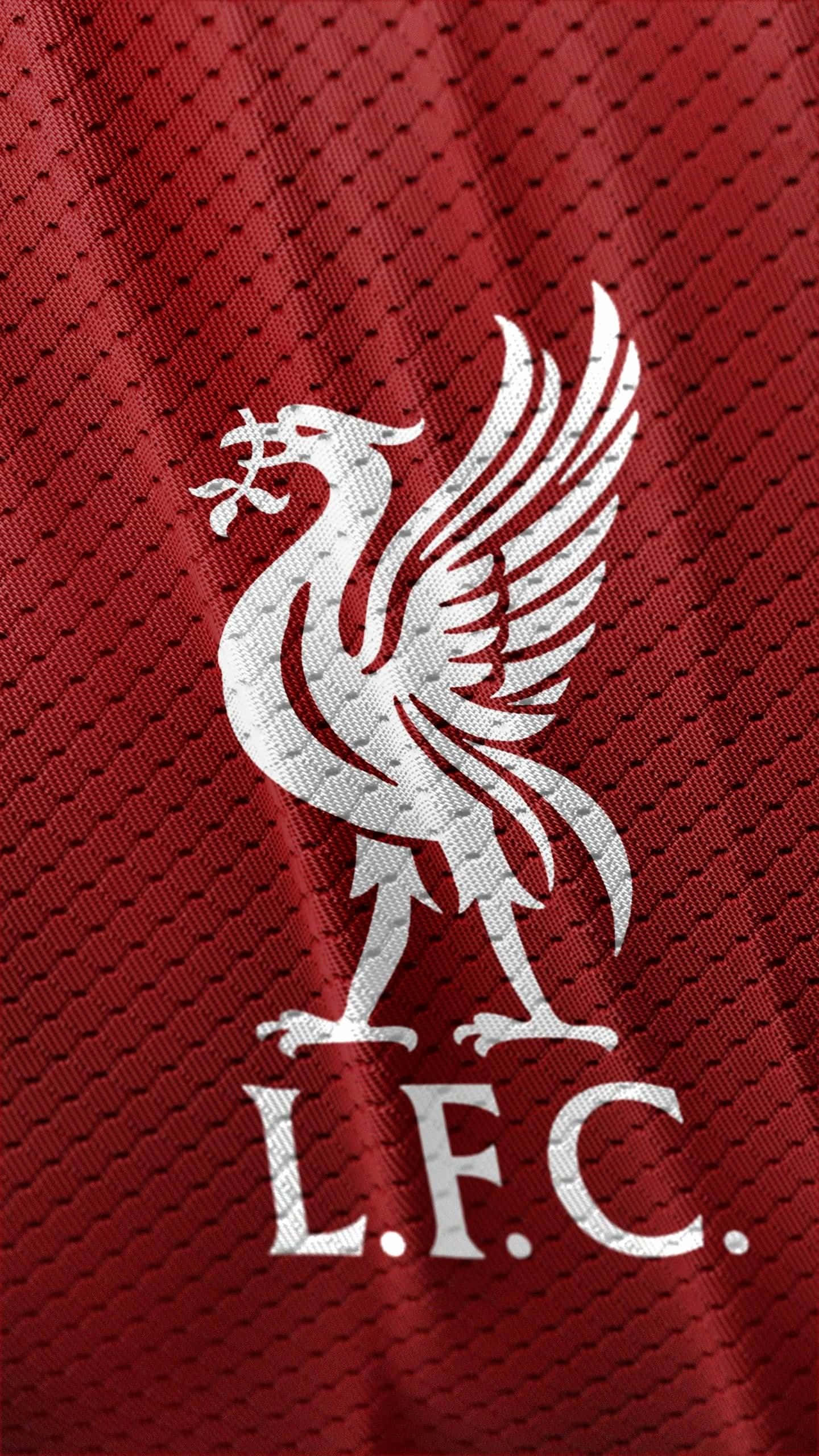 Liverpool Logo 桌布 壁紙 — 一個帶有有翼利物鳥的白色利物浦足球俱樂部徽章，大膽地矗立在帶有紋理的紅色運動球衣布料上。