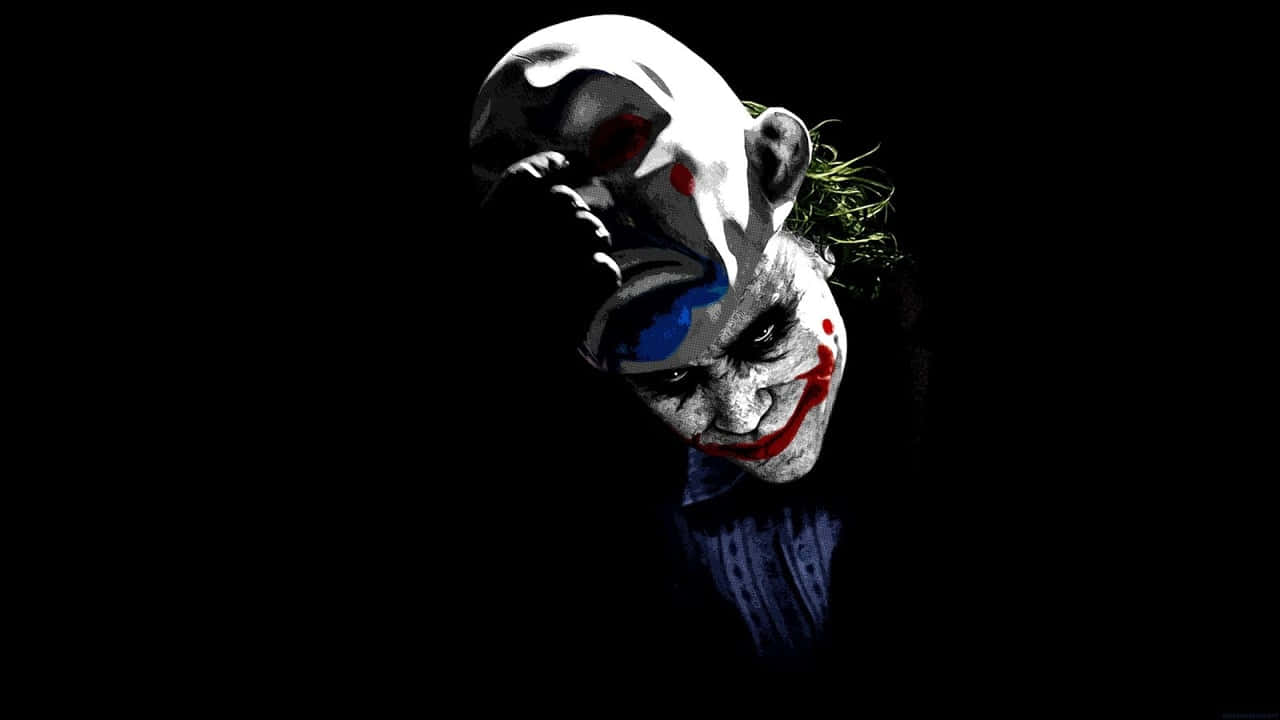 Mask 桌布 壁紙 — 一個帶有污跡化妝和狂野頭髮的威脅性小丑，在漆黑背景下強烈凝視。
