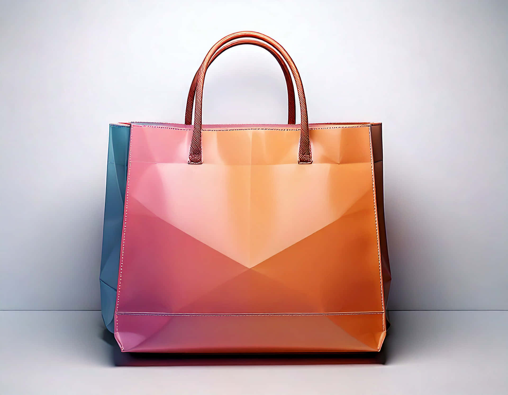 Shopping bag 壁紙 — 一個帶有漸變粉紅橙色和藍綠色面板以及棕色手柄的光面幾何購物袋放在白色表面上。