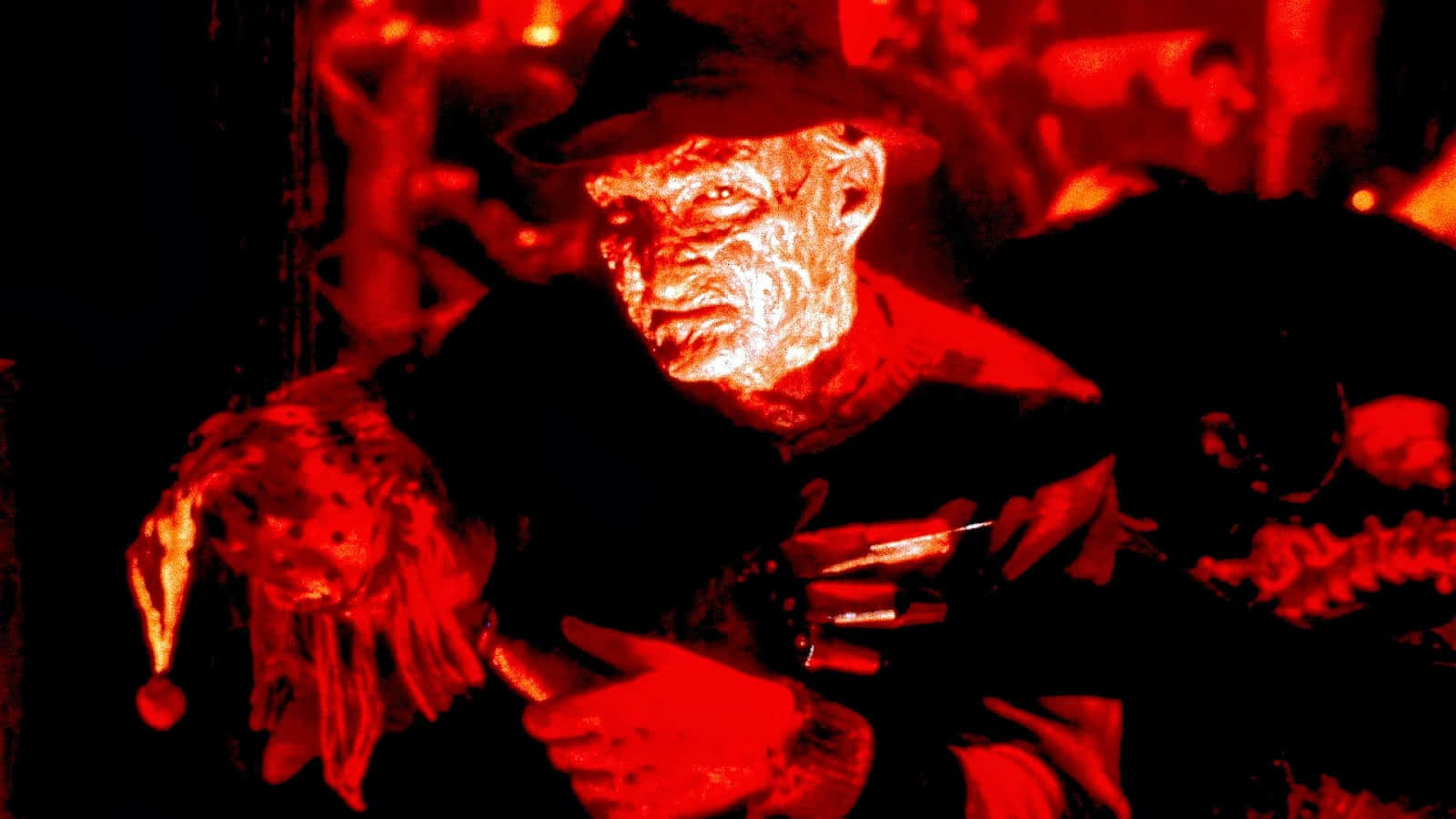 Freddy Krueger 桌布 壁紙 — 一個帶有燒傷臉孔和帽子的恐怖角色，在強烈紅光下手持武器怒視。