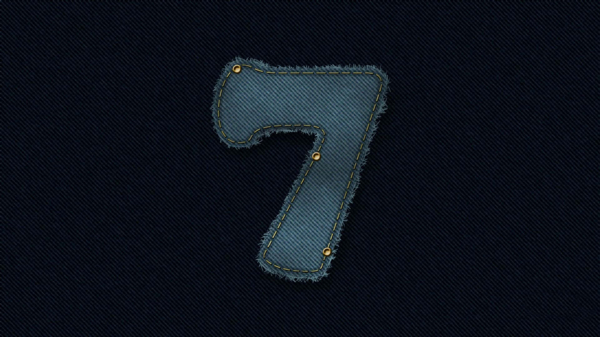 Number 7 桌布 壁紙 — 一個帶有牛仔布紋理的數字七，搭配黃色縫線和鉚釘，在深色牛仔布背景上格外突出。