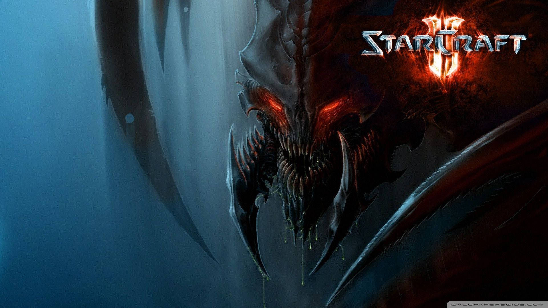 Starcraft 桌布 壁紙 — 一個帶有發光紅眼和尖牙的威脅性惡魔面孔從黑暗煙霧中浮現，背景是藍色和火焰。