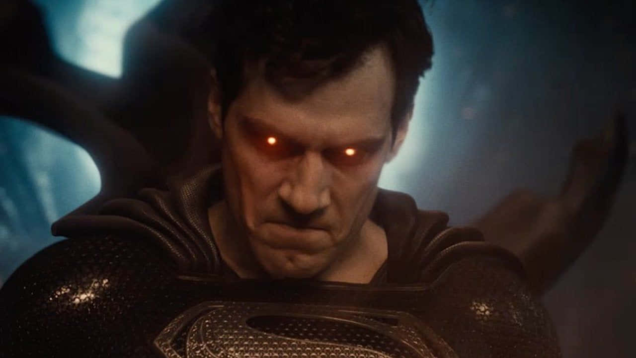 Zack Snyders Justice League 桌布 壁紙 — 一個帶有發光紅眼和深色套裝的威脅性超級英雄，在陰影藍色背景下強烈凝視。