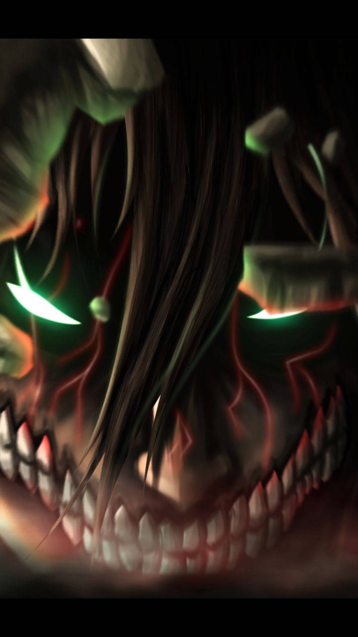Attack On Titan Titan Eren 桌布 壁紙 — 一個帶有發光綠色眼睛和尖銳牙齒的威脅性動漫巨人潛伏在黑暗中。