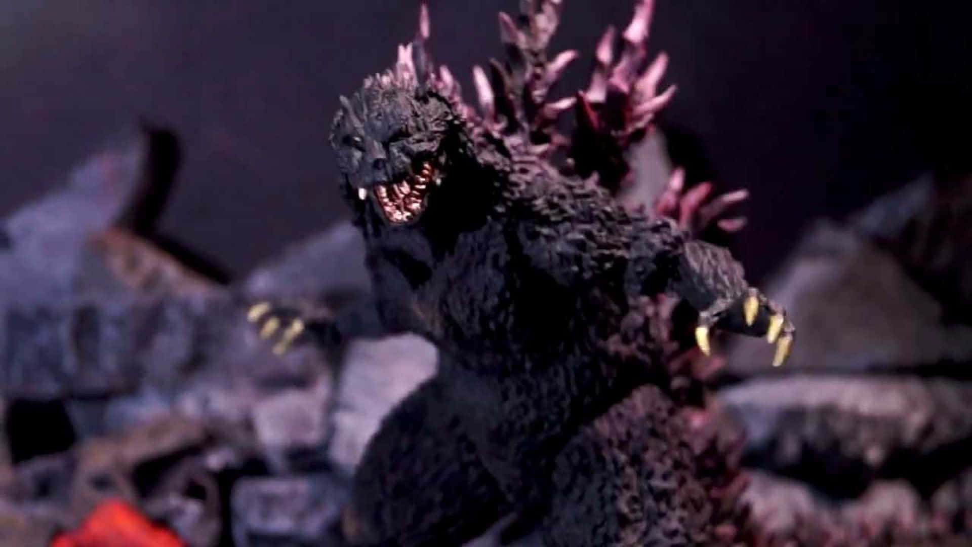 Godzilla 2000 桌布 壁紙 — 一個帶有發光黃色爪子和尖刺背部的威脅性哥吉拉人偶，在戲劇性的紫色燈光下站在瓦礫中。