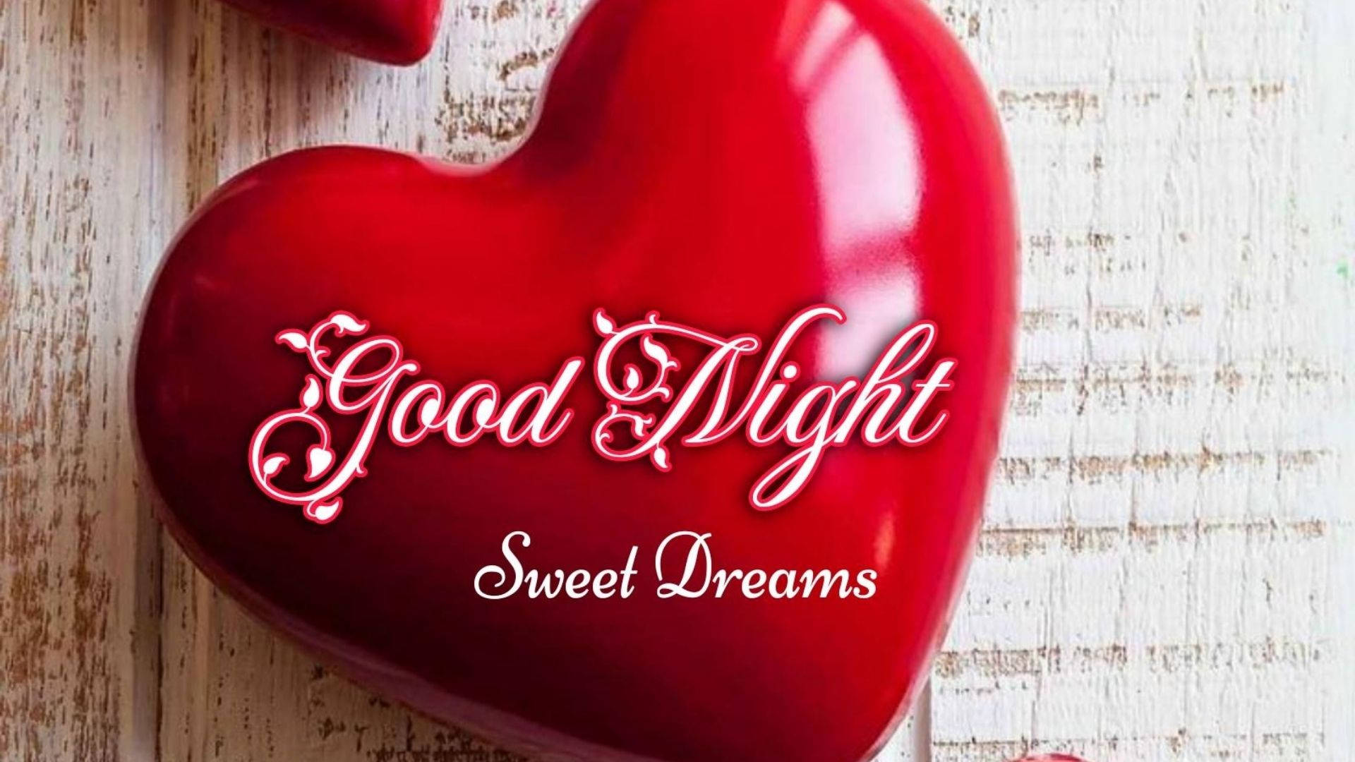 dreams 桌布 壁紙 — 一個帶有白色「Good Night Sweet Dreams」字樣的亮面紅色心形物體，放置在經風化的白色木質表面上。
