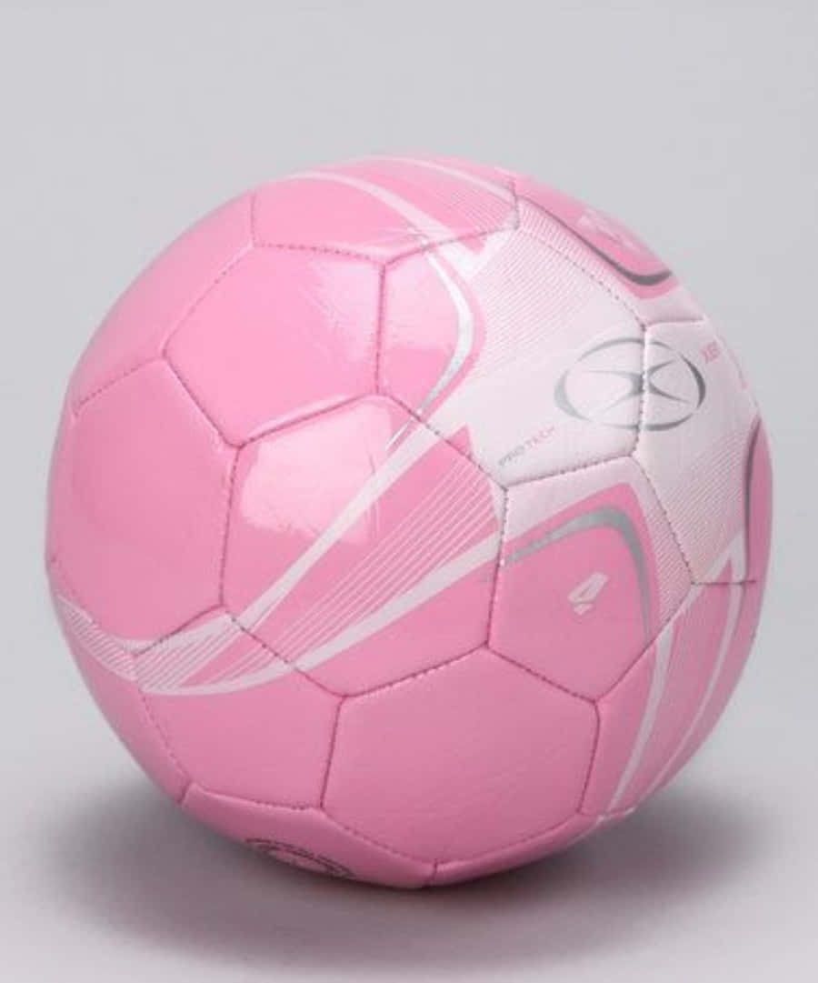 Pink Soccer Ball 桌布 壁紙 — 一個帶有白色和銀色漩渦圖案的光澤粉紅色足球，置於純灰色背景中央。