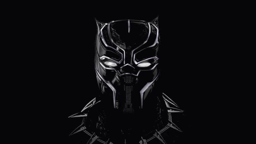 Marvel Black And White 桌布 壁紙 — 一個帶有白色眼睛的威脅性黑豹面具在漆黑背景中發光。