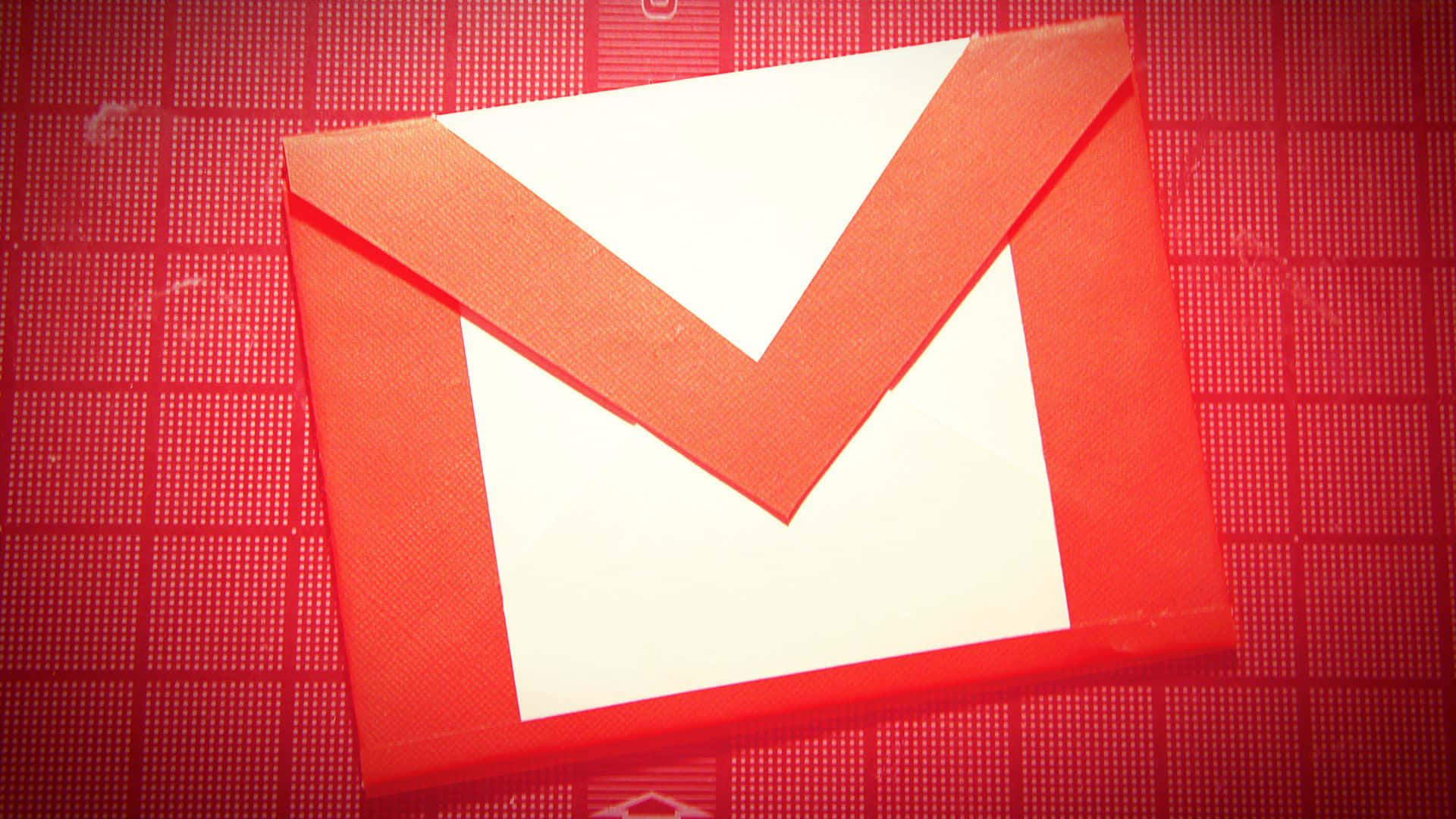 Gmail 動圖 桌布 壁紙 — 一個帶有白色翻蓋的紅色紋理信封圖示，居中放置在紅色網格圖案背景上。