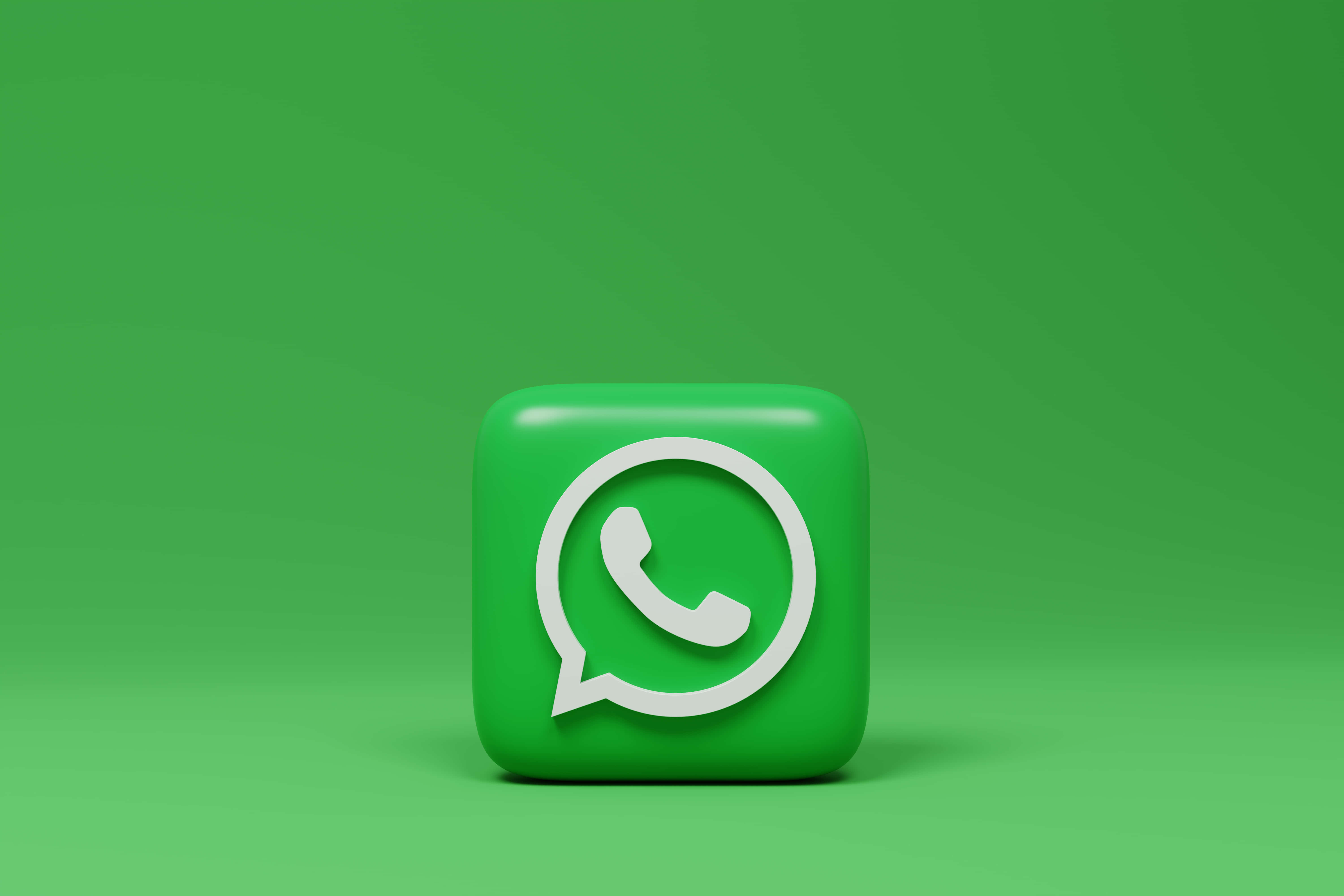 WhatsApp 桌布 壁紙 — 一個帶有白色電話符號的光面綠色WhatsApp應用程式圖標，位於純綠色漸變背景中央。