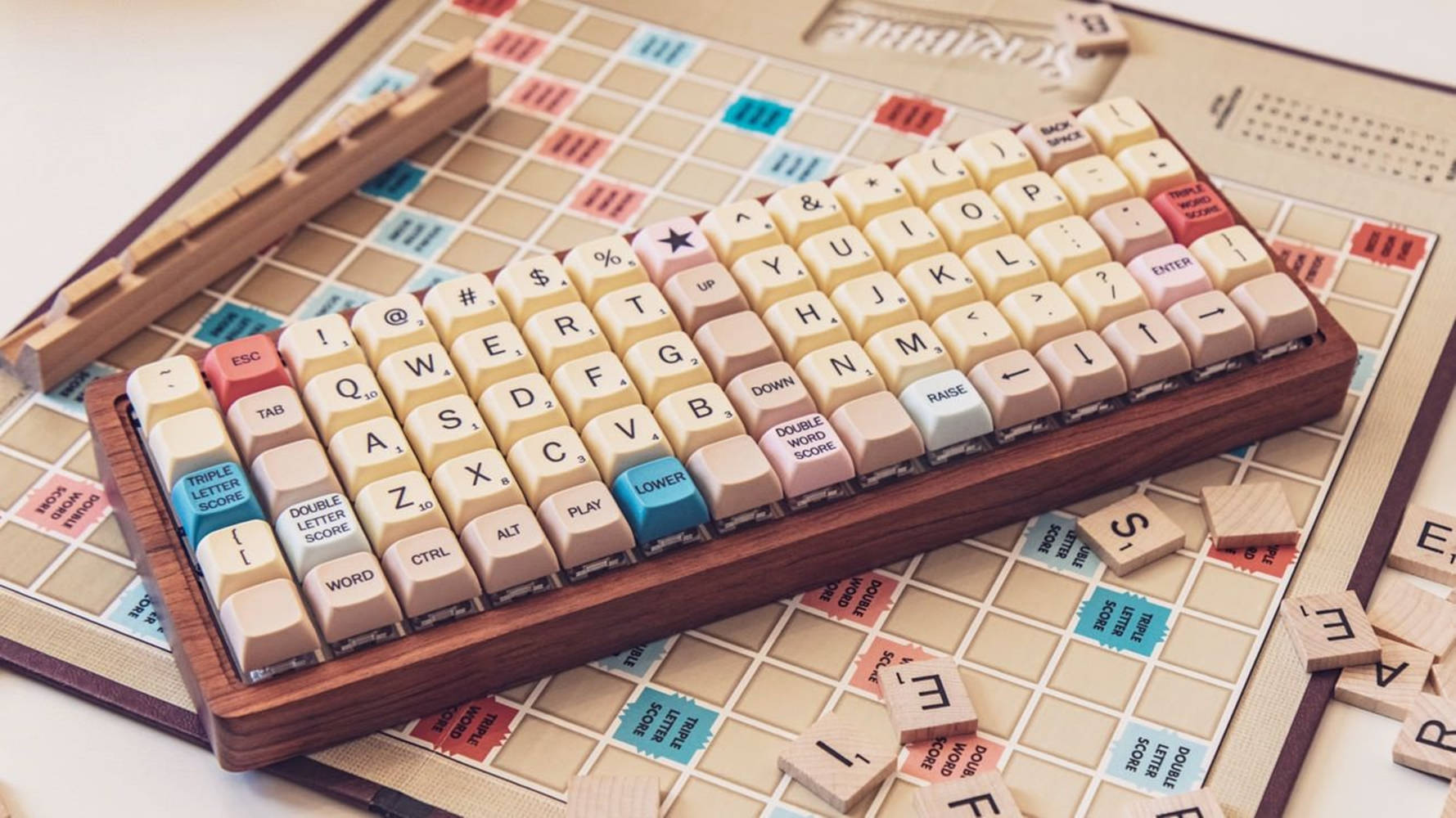 帶有粉彩色按鍵的木製鍵盤，放置在帶有字母牌的Scrabble棋盤上。 — 鍵盤 GIF 壁紙