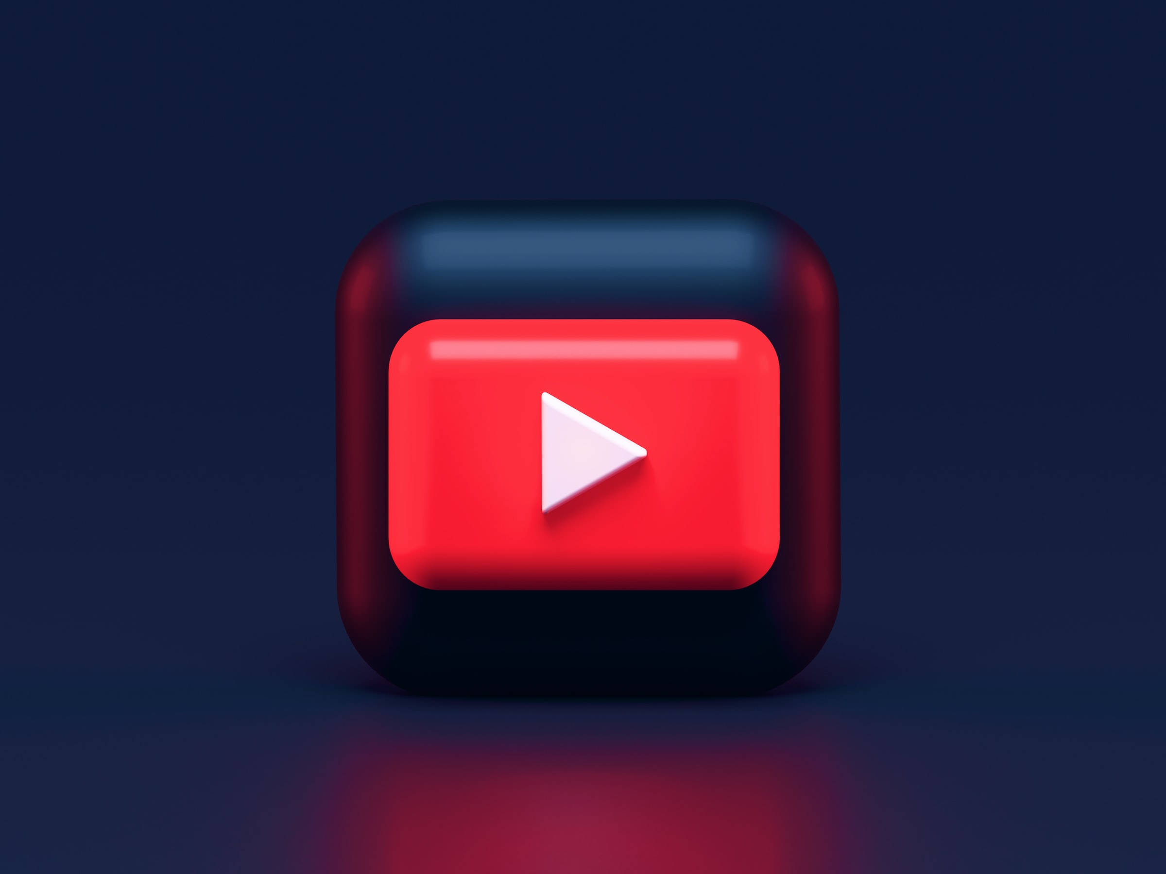 音樂 桌布 壁紙 — 一個帶有紅色和黑色漸變的亮面3D渲染YouTube播放按鈕圖示，背景為深藍色。