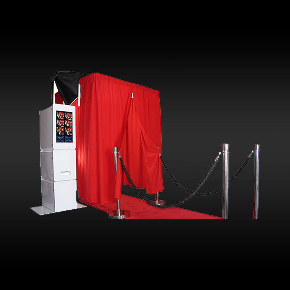 Photo Booth 桌布 壁紙 — 一個帶有紅色窗簾和天鵝絨繩的照相亭，在深色背景下，準備好迎接華麗的活動。