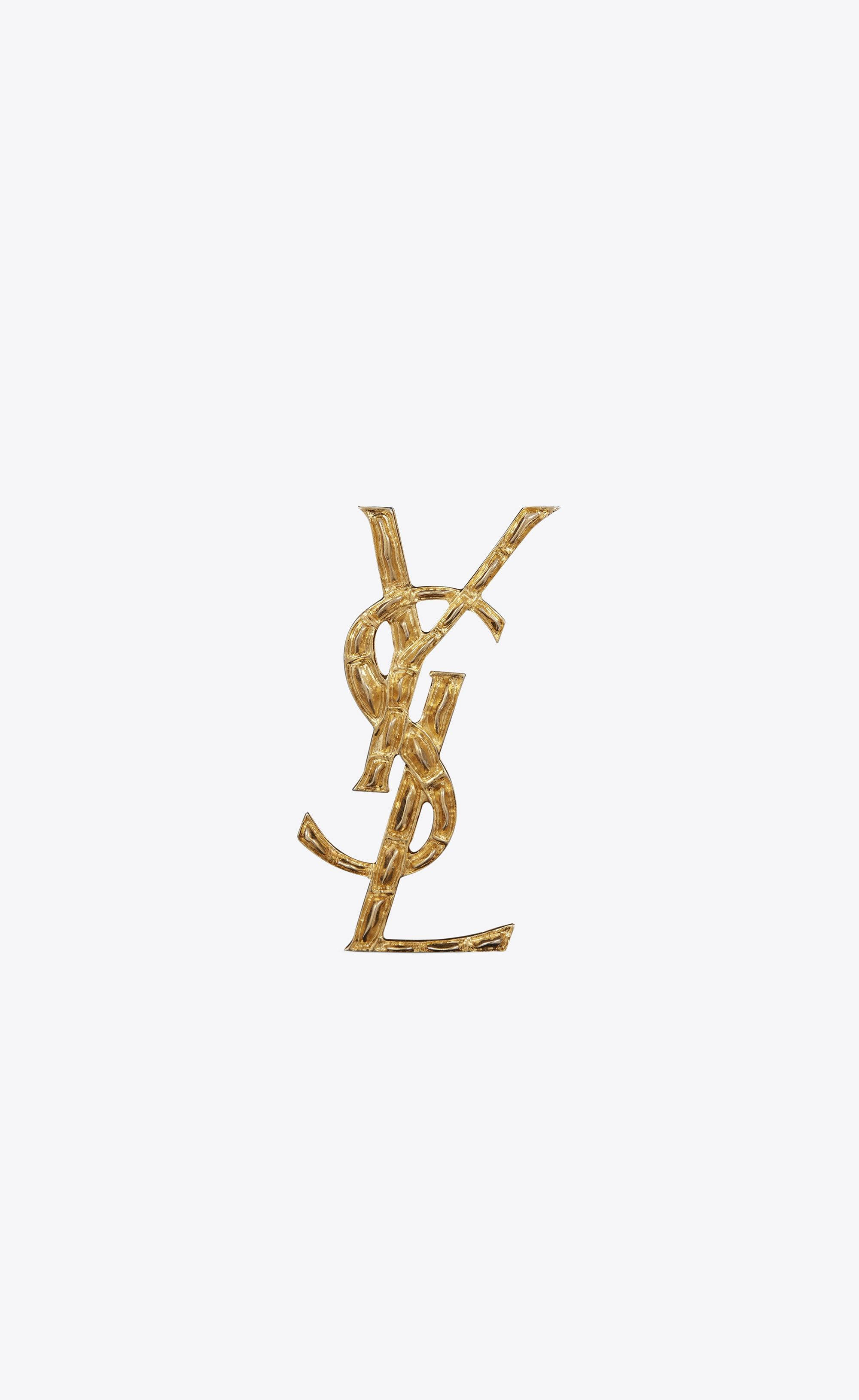 YSL 桌布 壁紙 — 一個帶有紋理表面的金色YSL字母組合標誌，居中放置在純淺灰色背景上。