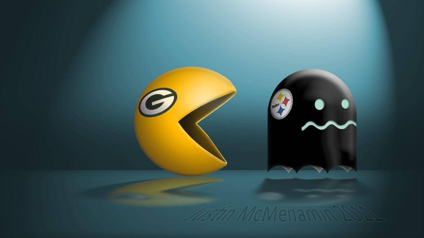 Packers 桌布 壁紙 — 一個帶有綠灣包裝工隊標誌的黃色 Pacman 在聚光燈下與一個帶有匹茲堡鋼人隊標誌的黑色鬼魂面對面。