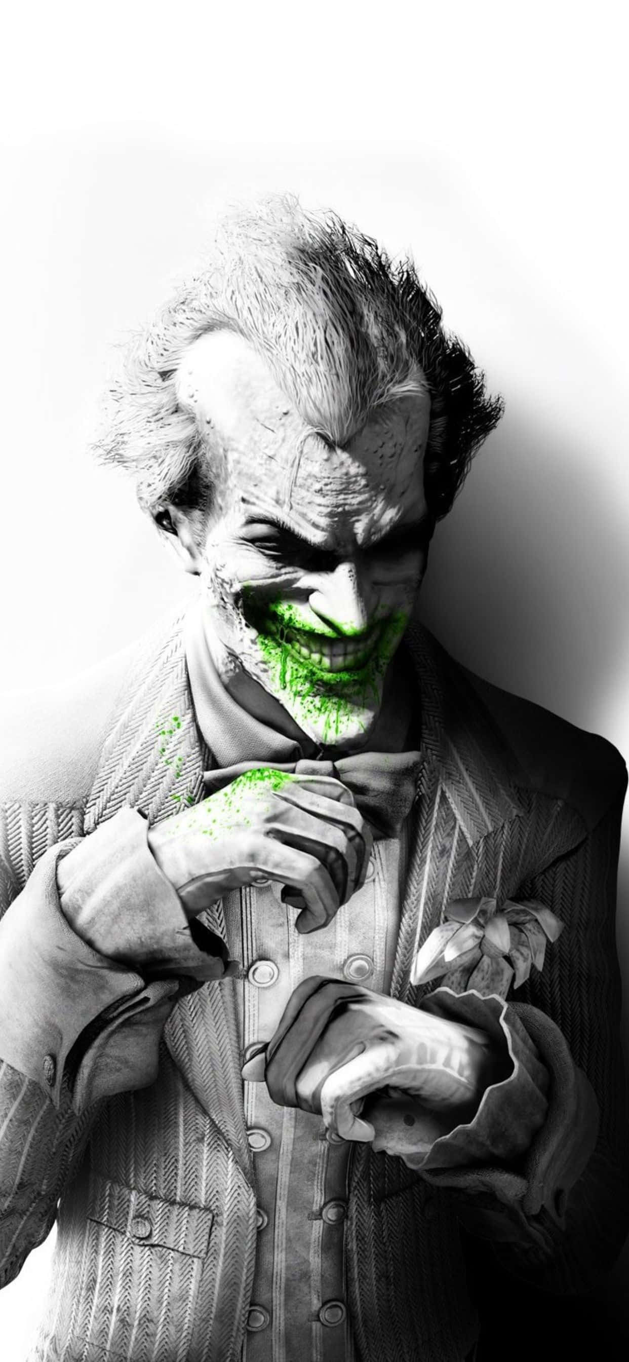 iPhone Xs Max Batman Arkham City 桌布 壁紙 — 一個帶有綠色塗抹笑容和狂野頭髮的威脅性小丑，在純白背景前調整他的領結。