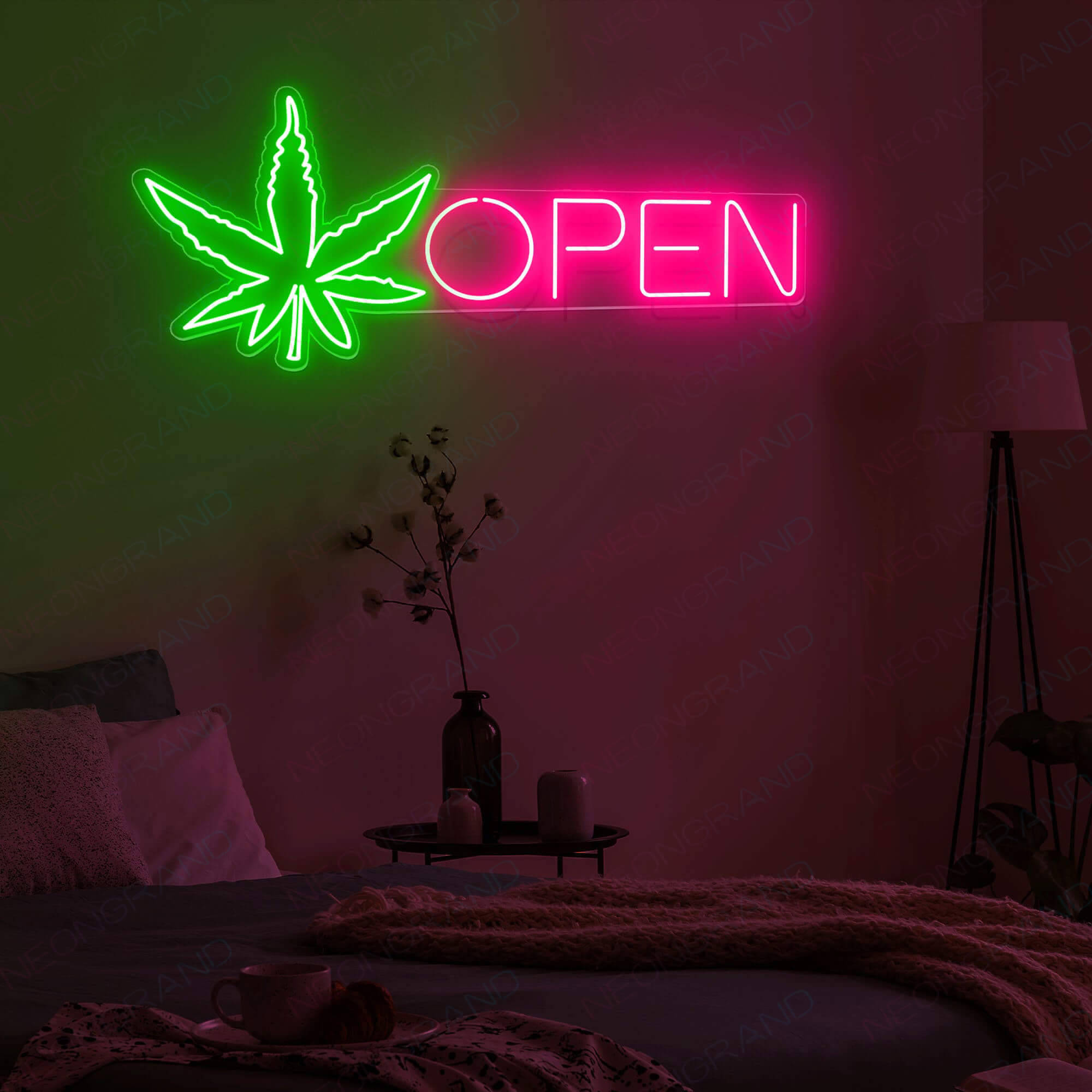 neon sign 桌布 壁紙 — 一個帶有綠色大麻葉和粉紅色開放文字的霓虹燈牌，在昏暗的床上方發光，床上有一個花瓶和一盞燈。