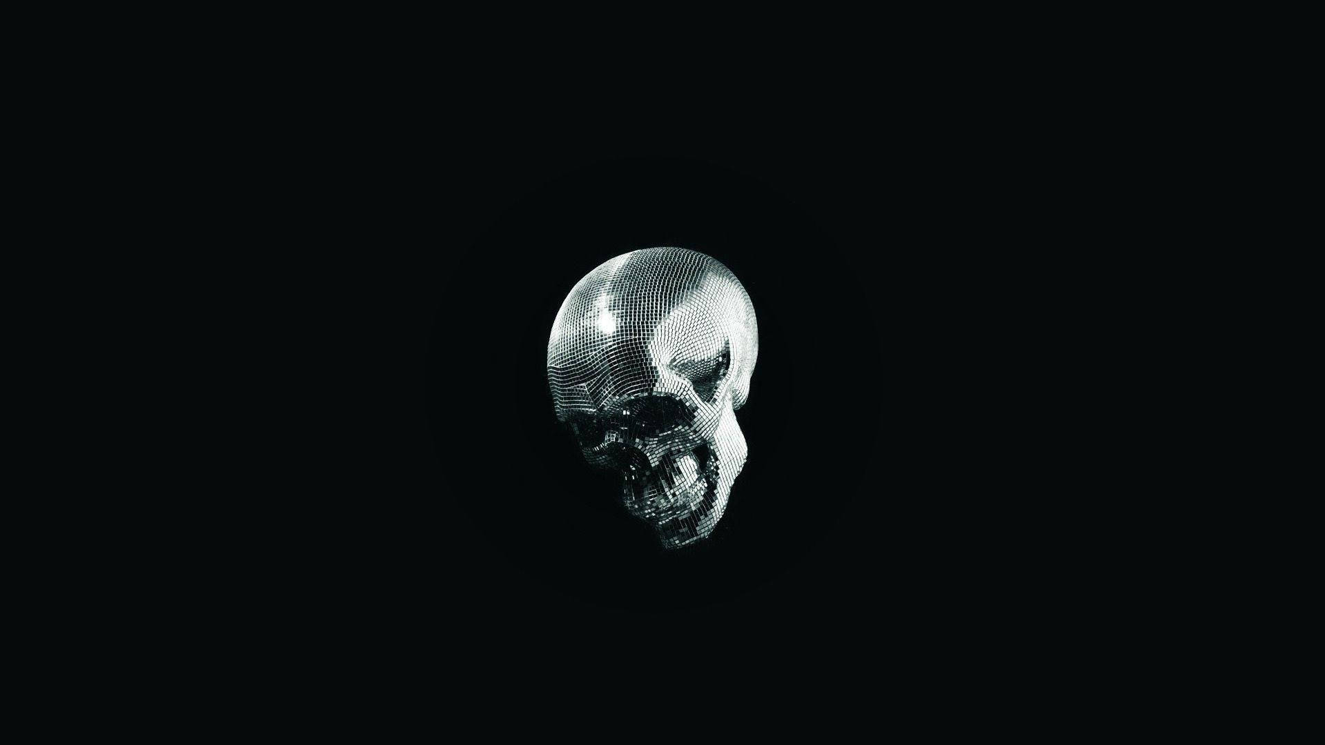 Black Skull 桌布 壁紙 — 一個帶有網格圖案的金屬骷髏頭在純黑色背景上隱約發光。