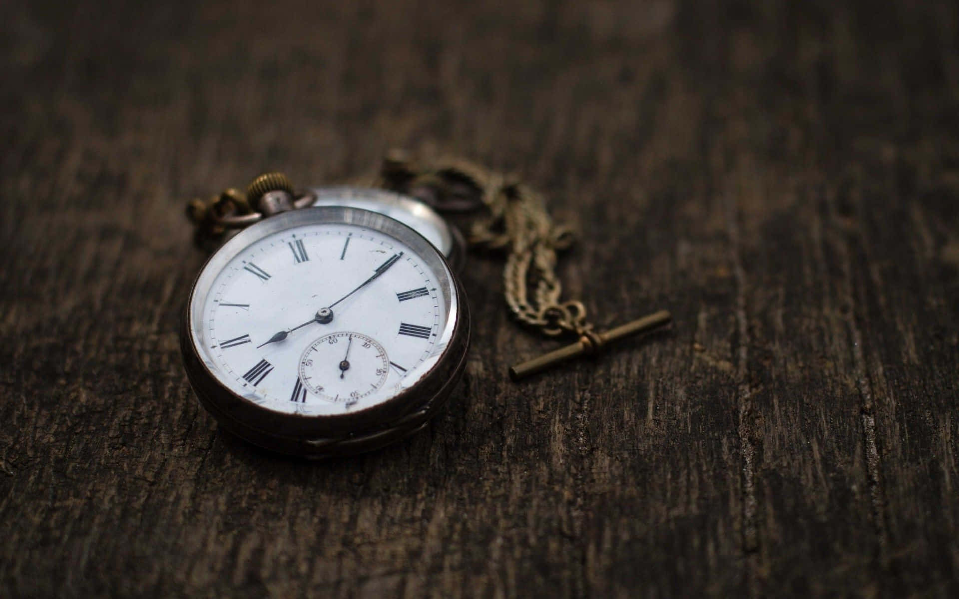 Clock 桌布 壁紙 — 一個帶有羅馬數字的古董懷錶放在風化的深色木質表面上。