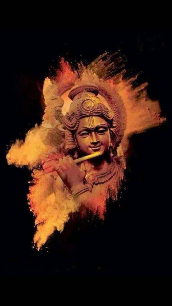 krishna iPhone 桌布 壁紙 — 一個帶有華麗頭飾的神聖人物正在吹奏長笛，鮮豔的橙色和黃色粉末在黑色背景上圍繞著他們爆發。