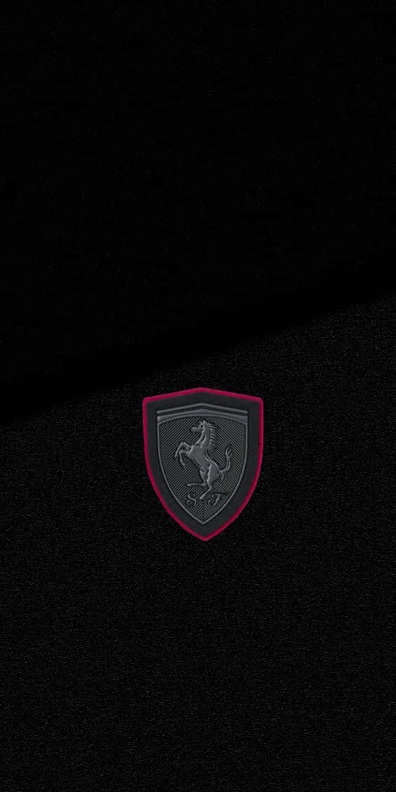 Pixel 3 Grid Autosport 桌布 壁紙 — 一個帶有躍馬標誌的法拉利徽章居中放置在帶有細紅色邊框的黑色紋理布料上。
