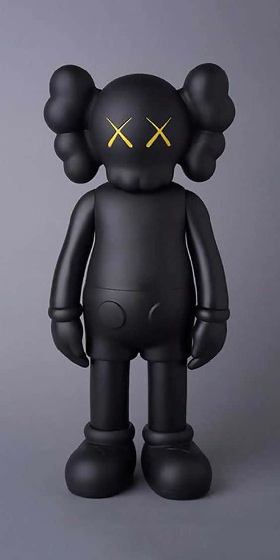 kaws pc 桌布 壁紙 — 一個帶有金色X眼睛的光澤黑色KAWS Companion公仔，站在純灰色工作室背景前。