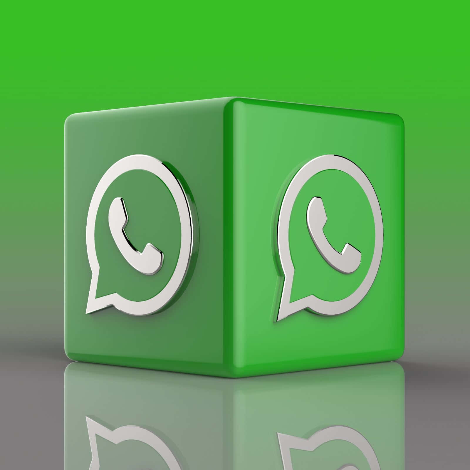 WhatsApp 桌布 壁紙 — 一個帶有銀色WhatsApp標誌的光澤綠色立方體，放置在反光表面上，背景為漸變綠色。