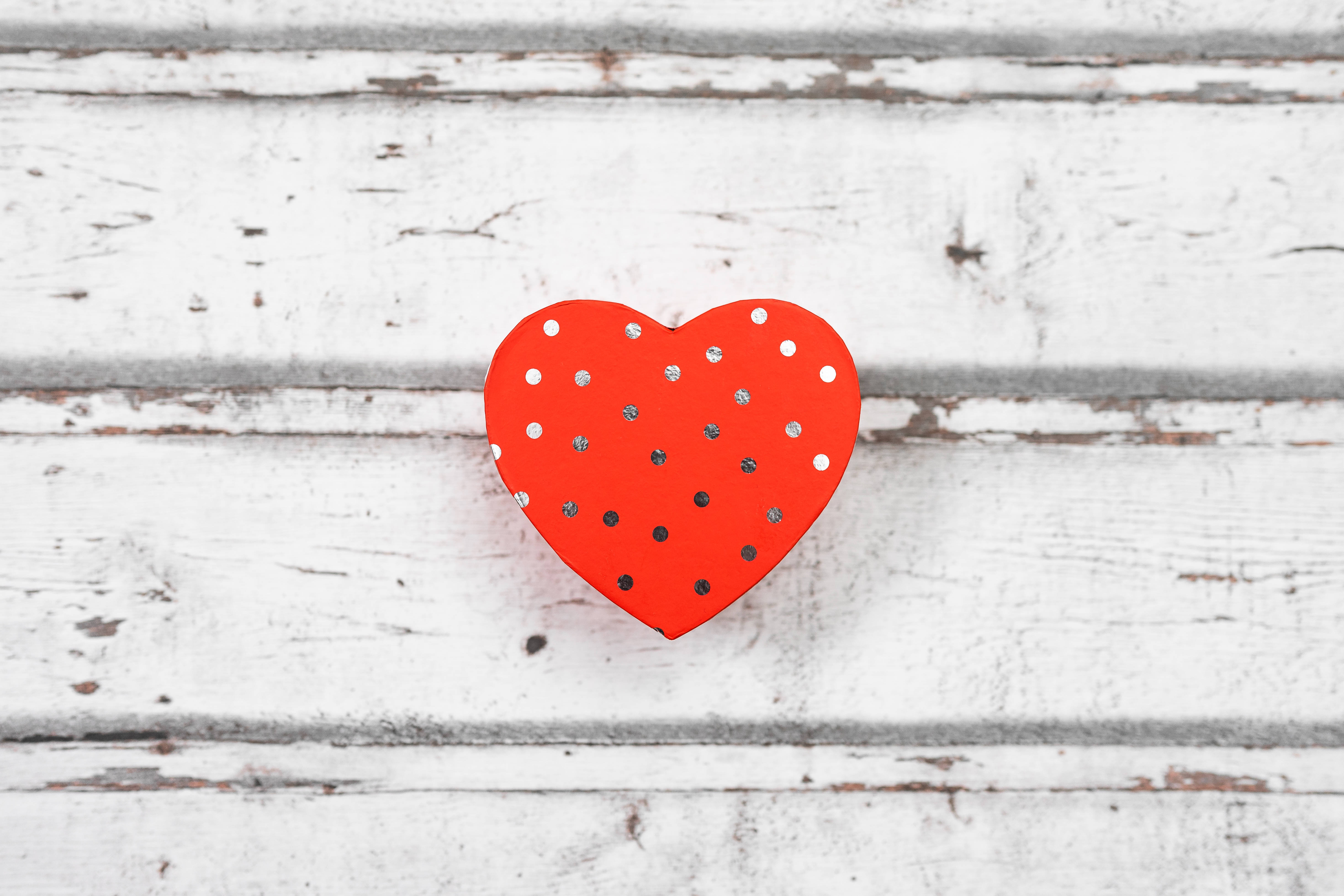 Aesthetic Heart 桌布 壁紙 — 一個帶有銀色和白色圓點的鮮紅色心形圖案，放置在經風化的白色木質表面上。