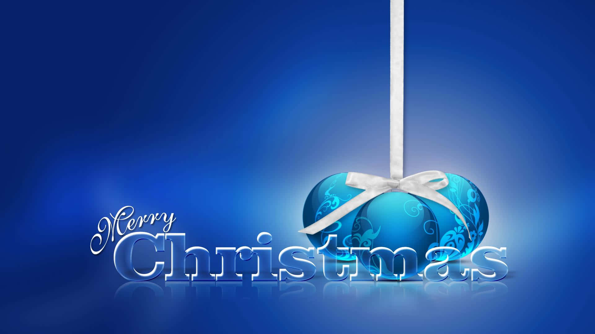 3d Christmas 桌布 壁紙 — 一個帶有銀色漩渦的光澤藍色聖誕裝飾，用白色絲帶掛在漸變藍色背景上，並帶有「Merry Christmas」文字。