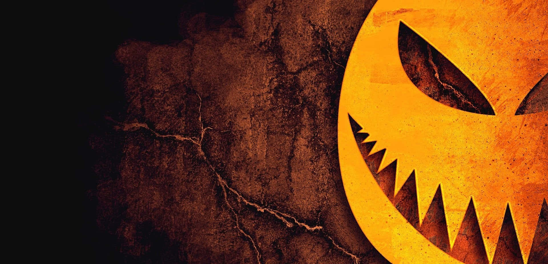 Orange Halloween 桌布 壁紙 — 一個帶有鋸齒狀牙齒和發光眼睛的橙色傑克南瓜燈臉孔，雕刻在黑暗背景下的裂紋紋理牆壁上。