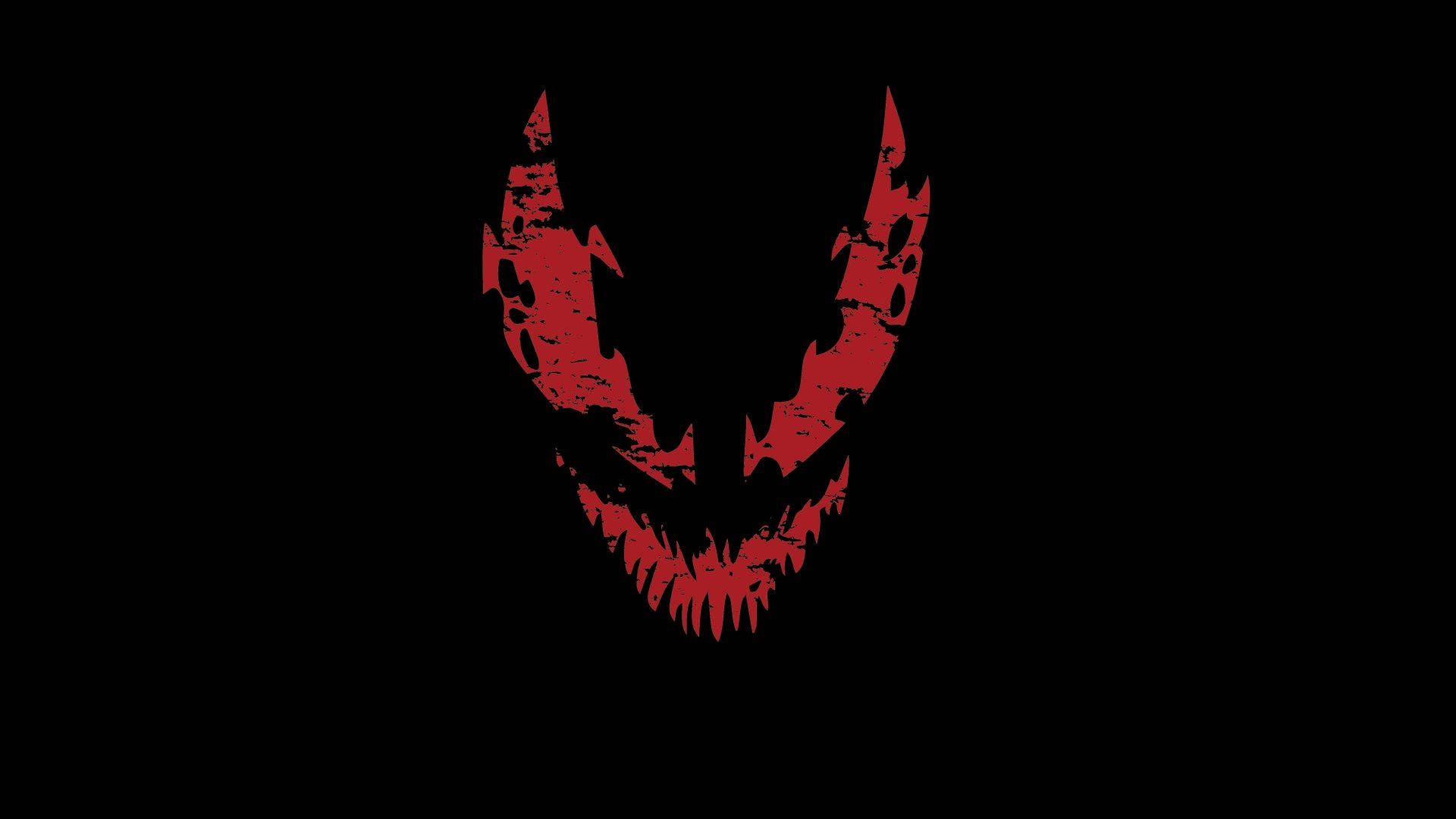 Venom Carnage 桌布 壁紙 — 一個帶有鋸齒狀牙齒和角的紅色恐怖頭骨在純黑色背景上發光。