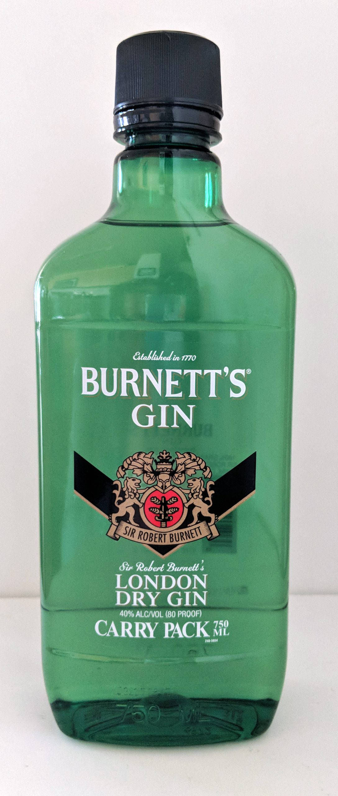 drinks 桌布 壁紙 — 一個帶有黑色蓋子和復古紋章標籤的Burnett's London Dry Gin綠色玻璃瓶，立在純白色背景前。