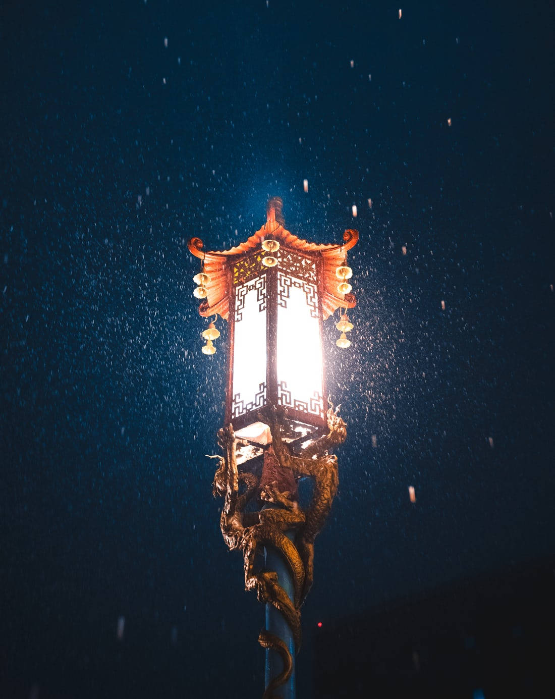 唐人街 桌布 壁紙 — 一個帶有龍紋的傳統發光燈籠，在黑暗的雪夜天空中溫暖地閃耀。