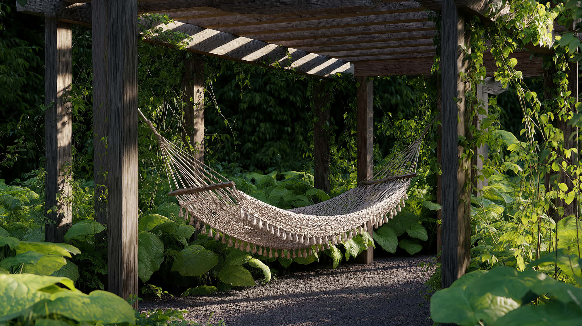 Relaxing Hammock Under Pergola in Lush Green Garden 壁紙 — 一個帶流蘇的米色流蘇吊床掛在一個被綠色藤蔓和大葉子覆蓋的木製涼棚下。
