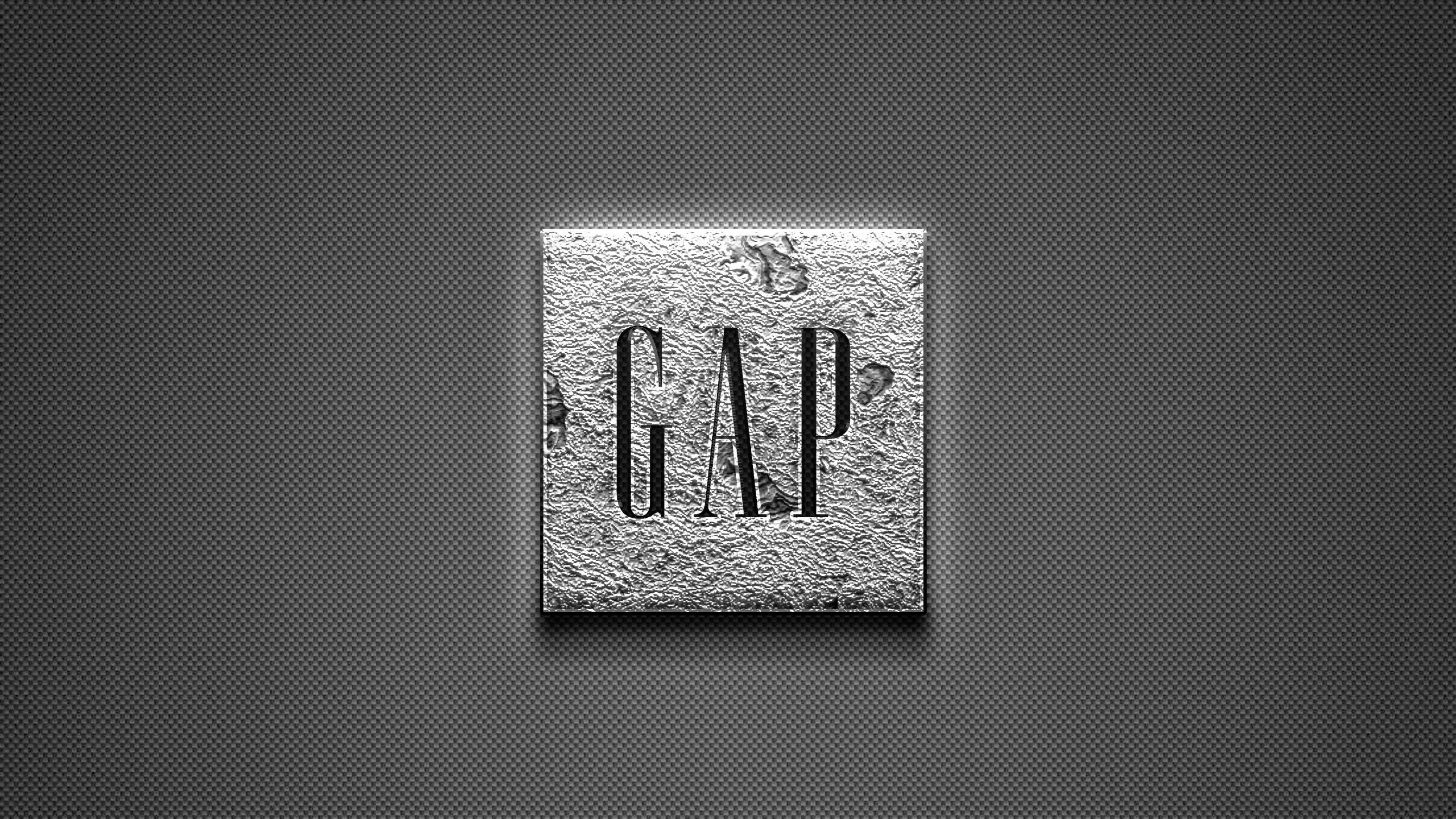 Gap 桌布 壁紙 — 一個帶紋理的金屬正方形，在深灰色穿孔背景上以粗體字壓印了GAP這個詞。