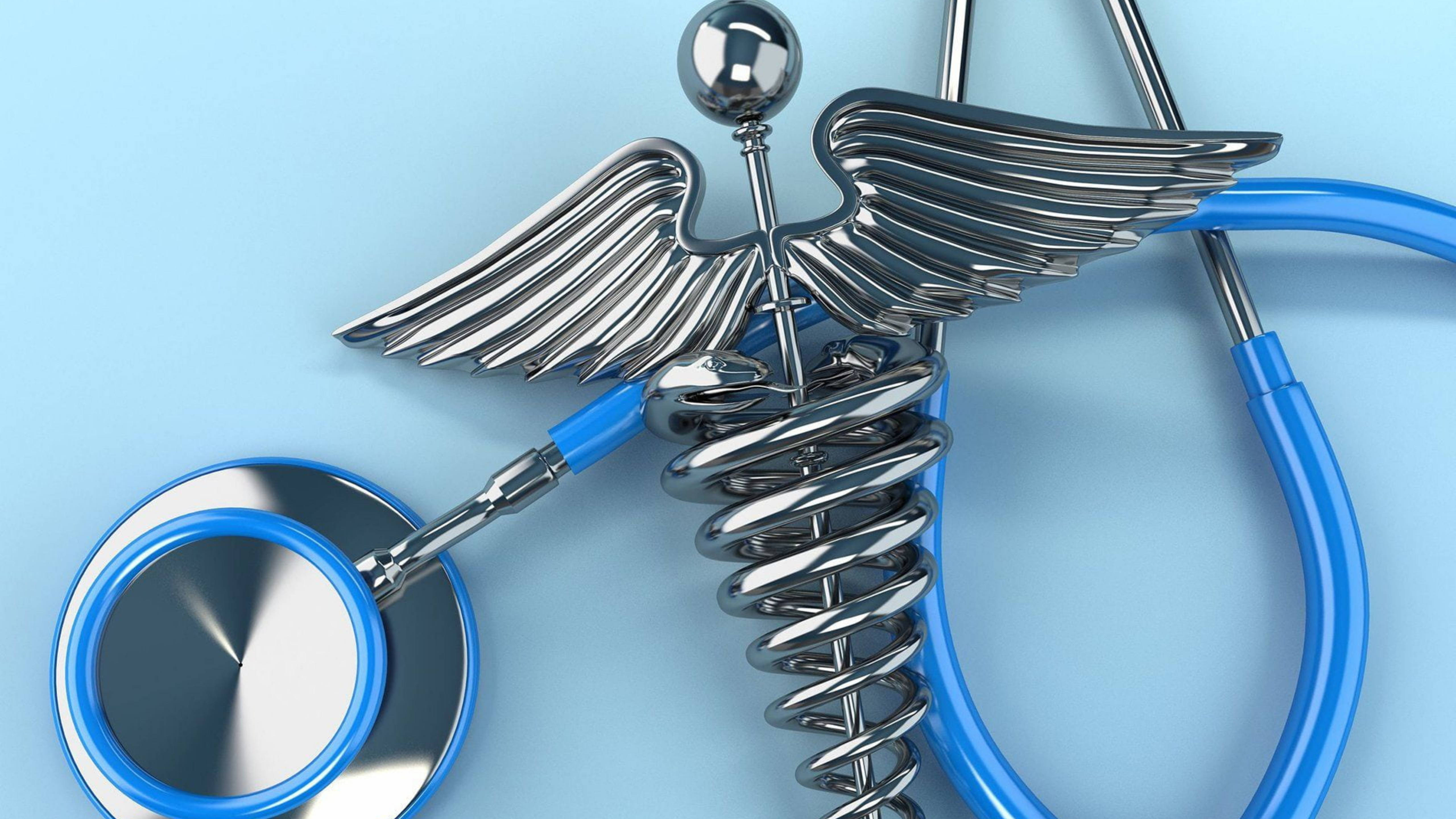 Stethoscope 桌布 壁紙 — 一個帶翅膀和纏繞杖的金屬雙蛇杖，與藍色聽診器交織在淺藍色背景上。