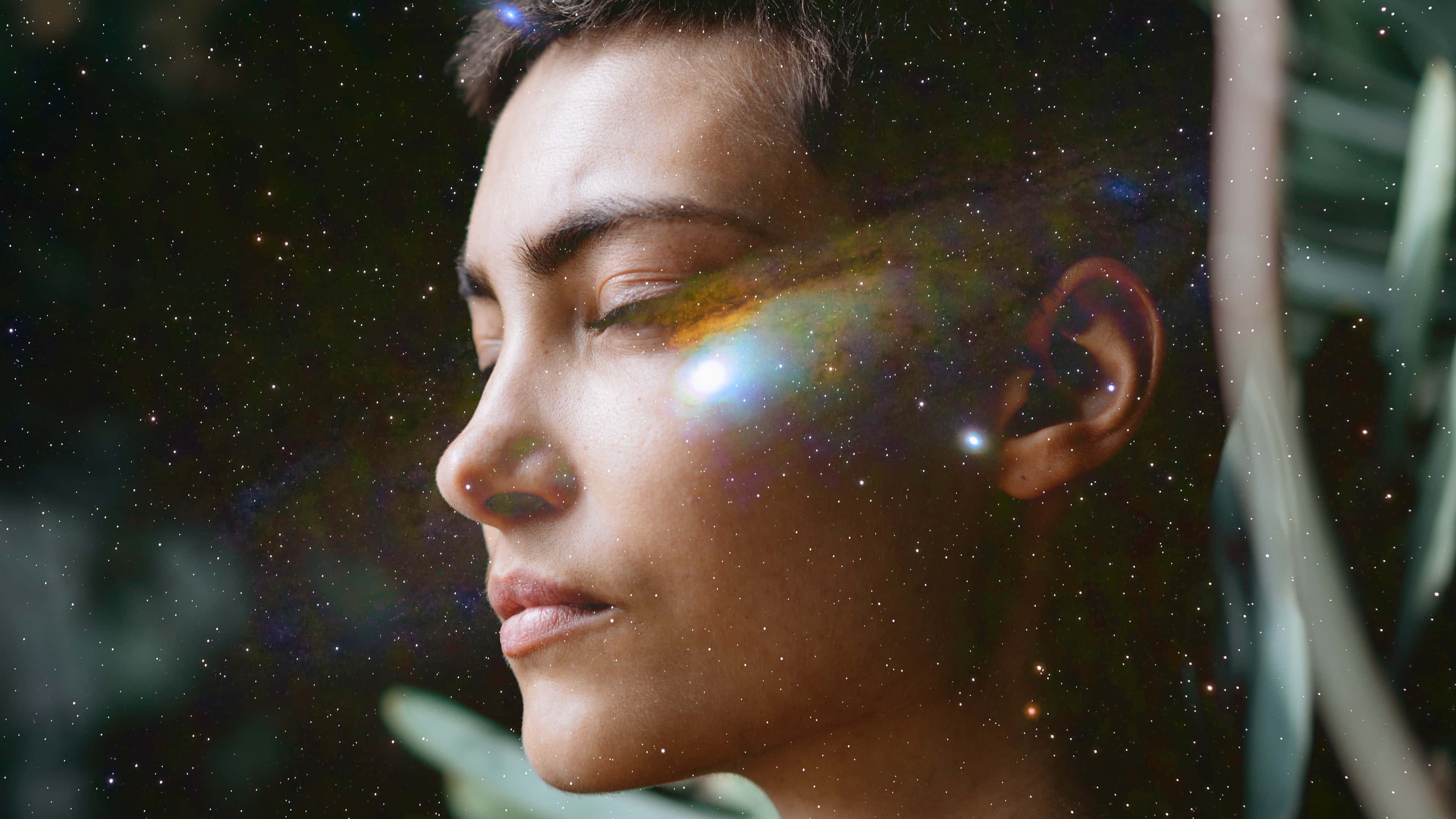銀河 桌布 壁紙 — 一個平靜的人物側面，宇宙星雲和星星融入他們的臉龐，背景為深色。