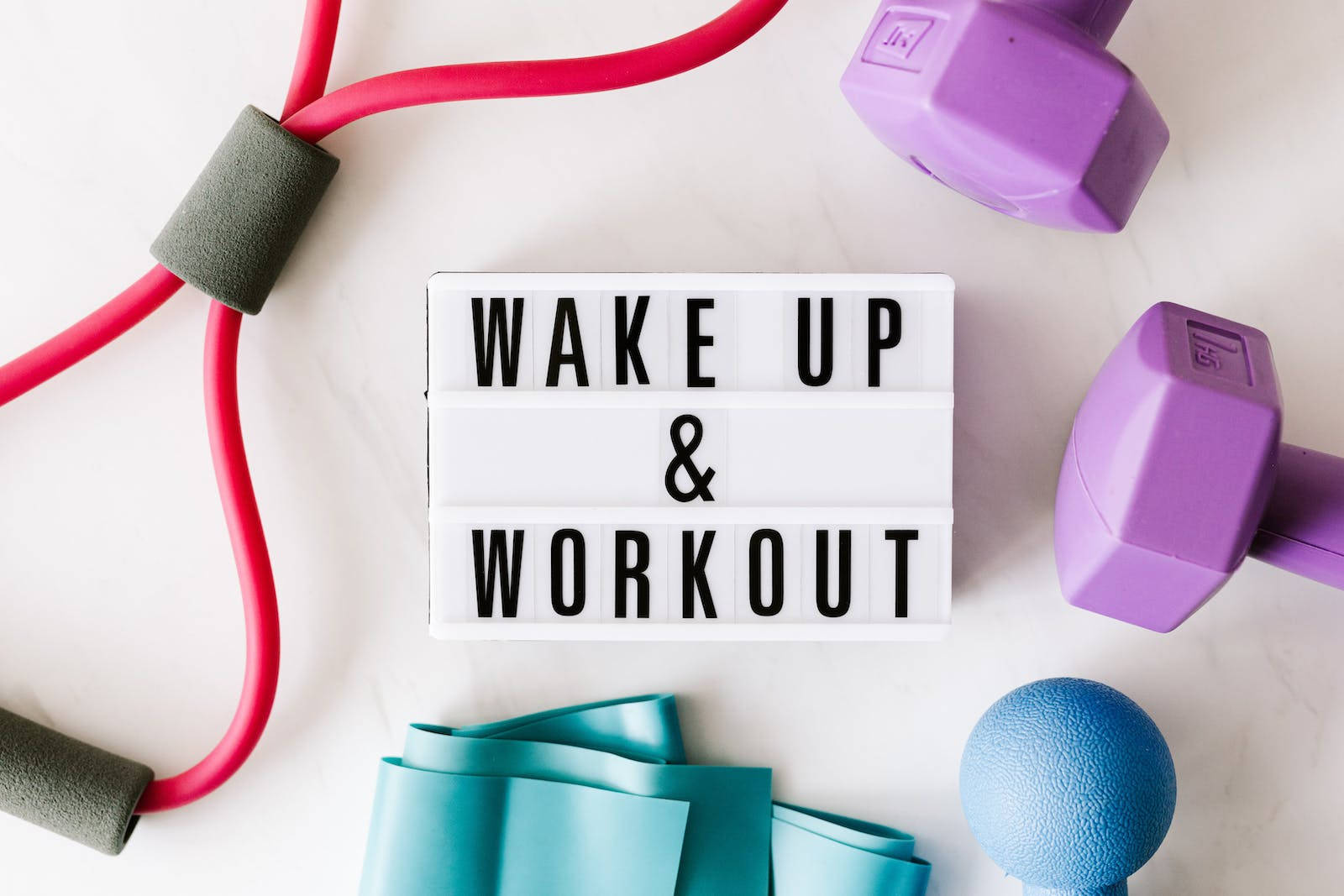 健身器材圍繞一個寫著wake up and workout的燈箱標誌排列。