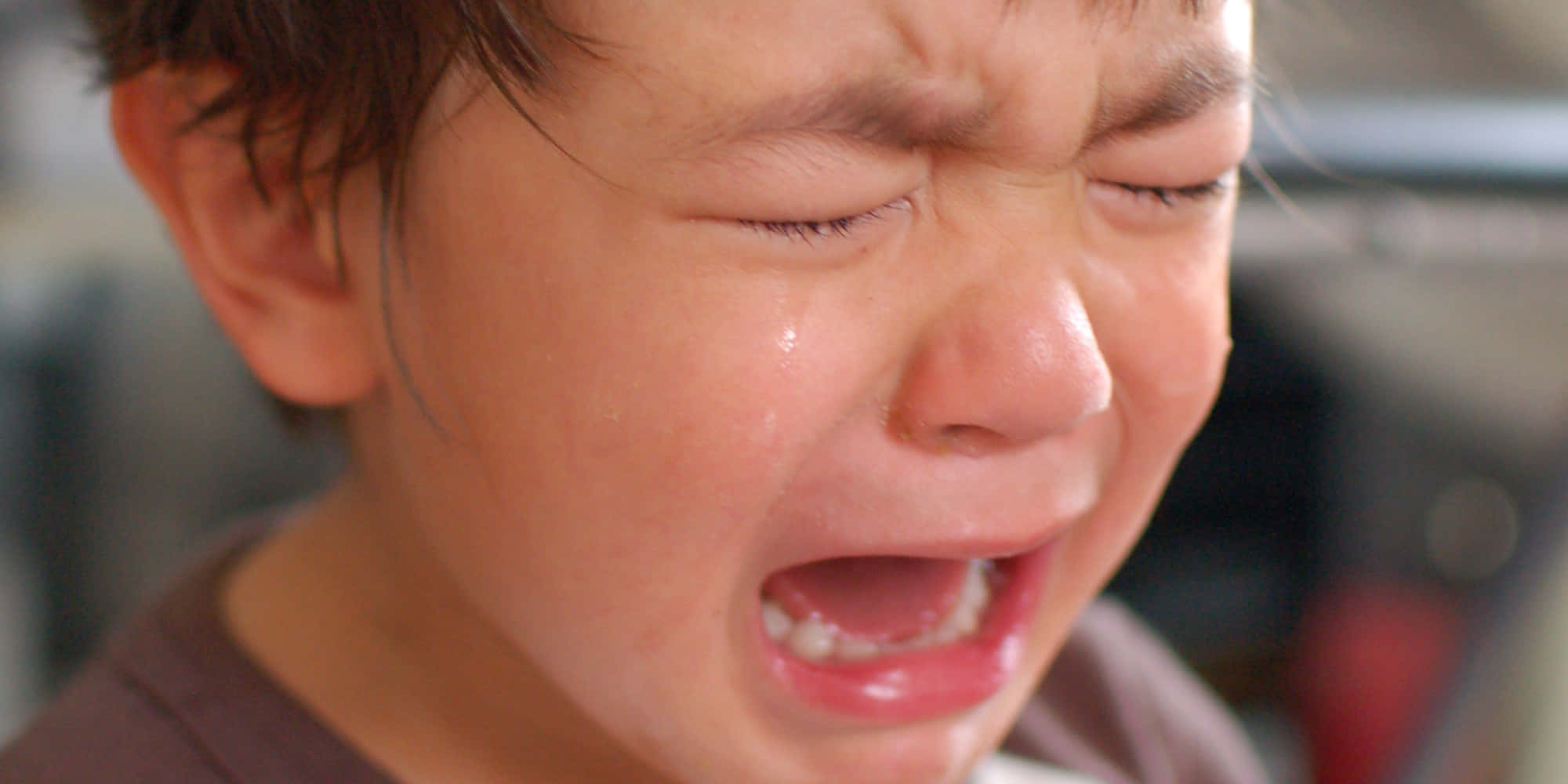 cry 桌布 壁紙 — 一個年幼孩子哭泣的特寫，淚水順著臉頰流下，嘴巴因痛苦而張開。