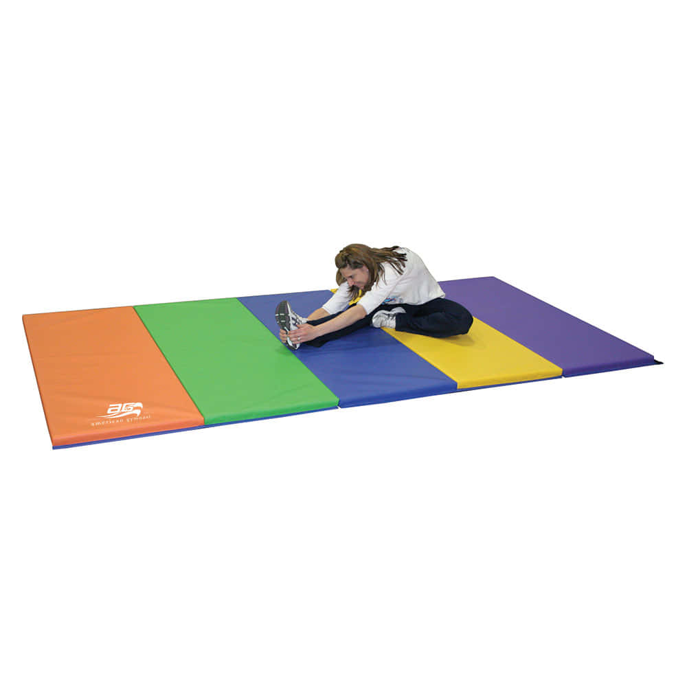 Gymnastics Mat 桌布 壁紙 — 一個年輕女孩在純白色背景前的彩色分段體操墊上伸展。