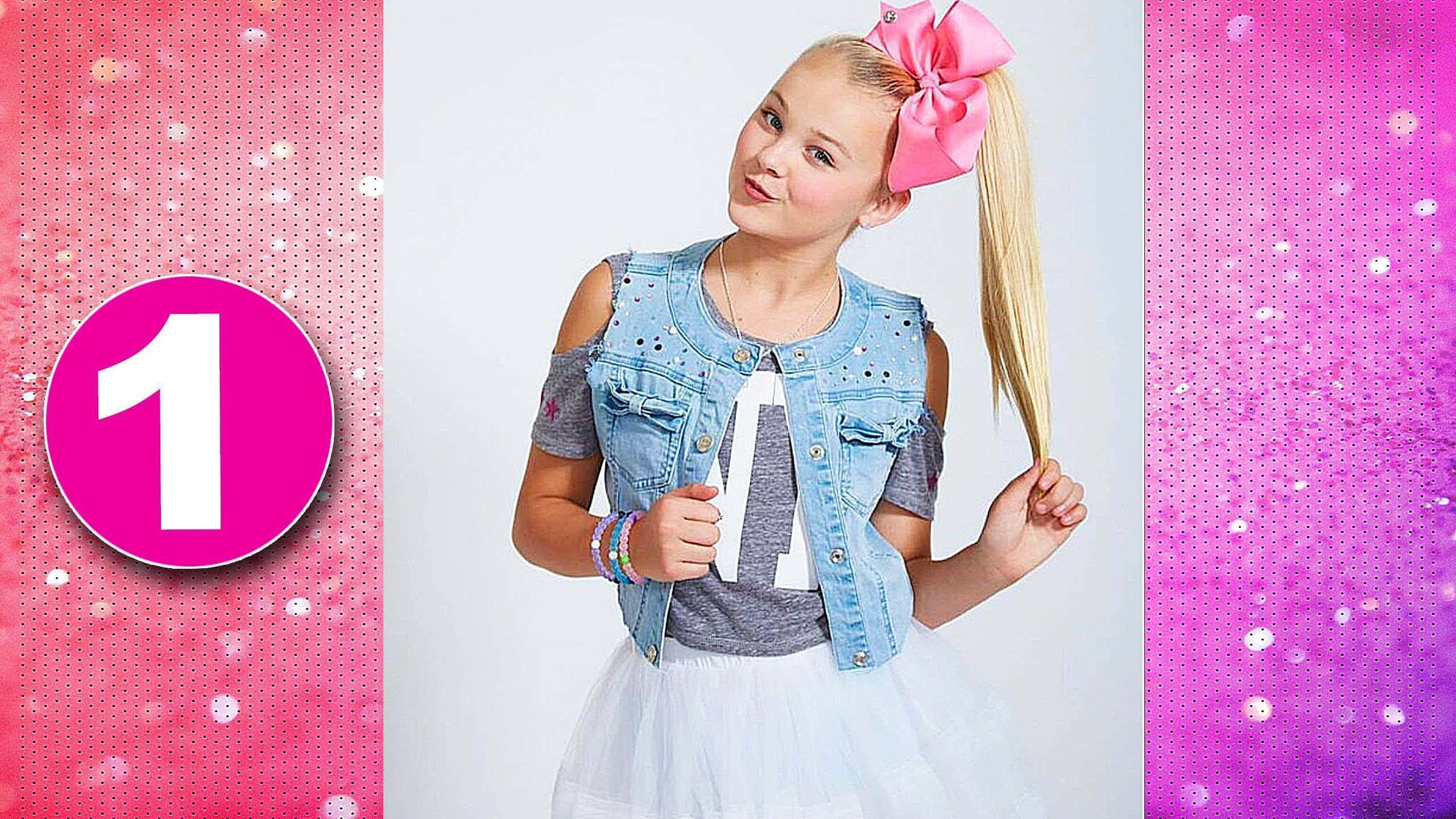 JoJo Siwa 桌布 壁紙 — 一個年輕女孩在馬尾辮上繫著粉紅色蝴蝶結，穿著牛仔背心，在閃閃發光的粉紅色和紫色背景前自信地擺姿勢。