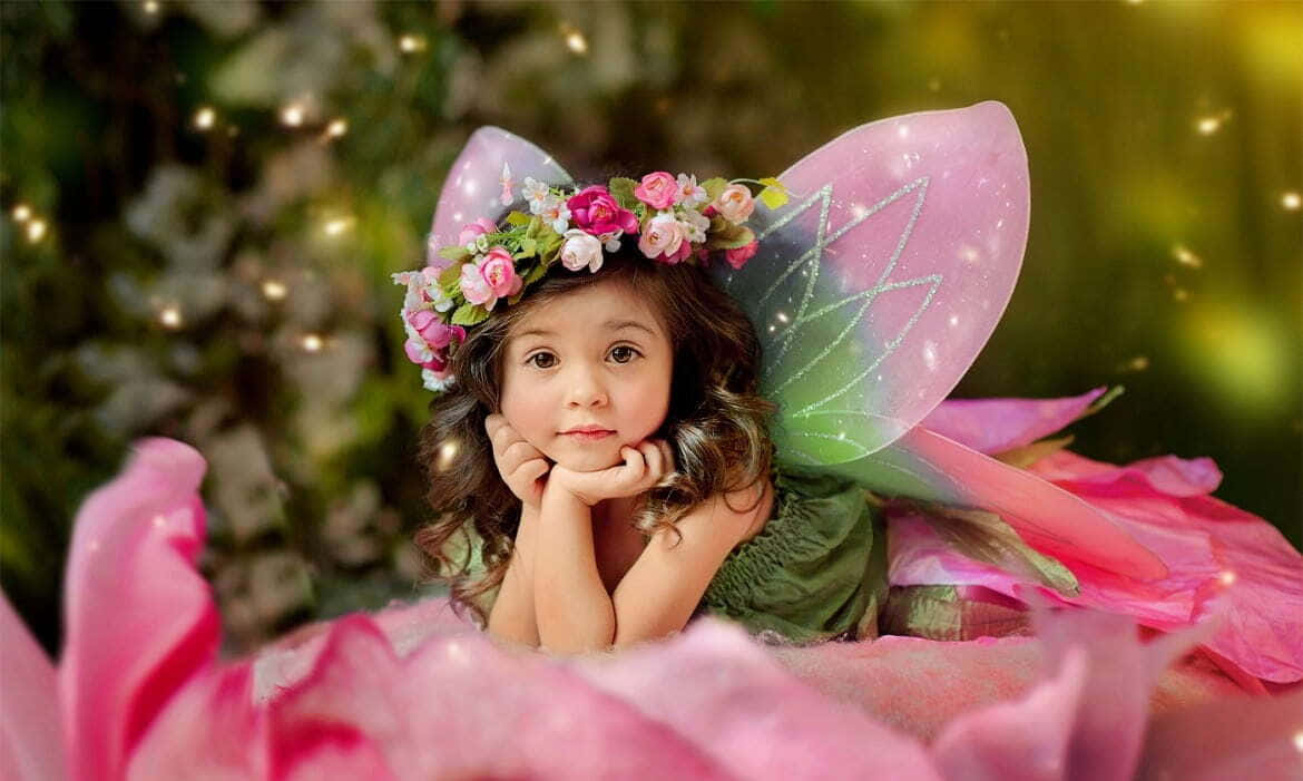 Cute Fairy 桌布 壁紙 — 一個年輕女孩打扮成仙女，擁有粉紅色的翅膀和花冠，若有所思地坐在一朵巨大的粉紅色花朵內。