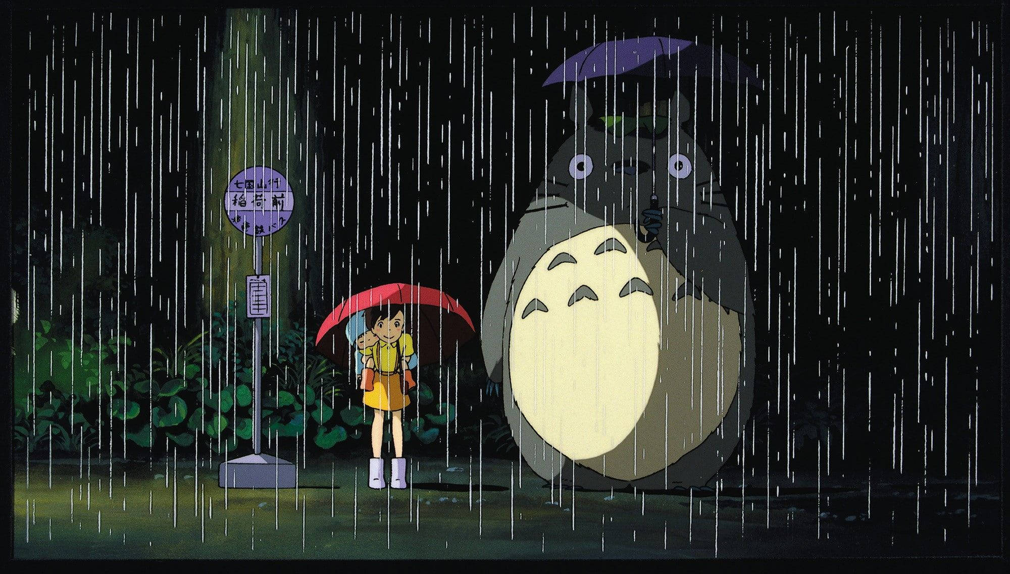 Studio 桌布 壁紙 — 一個年輕女孩拿著紅色雨傘，在夜晚的大雨中站在一個巨大而溫柔的龍貓旁邊。