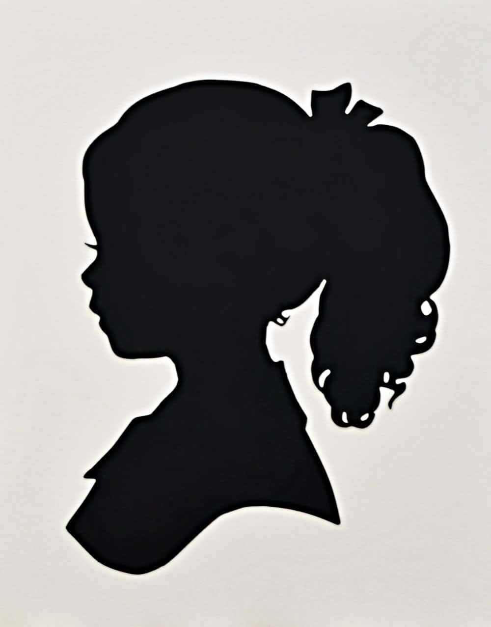 Silhouette 桌布 壁紙 — 一個年輕女孩的側面輪廓，捲髮束起，在樸素的淺色背景上呈現出鮮明的黑色剪影。