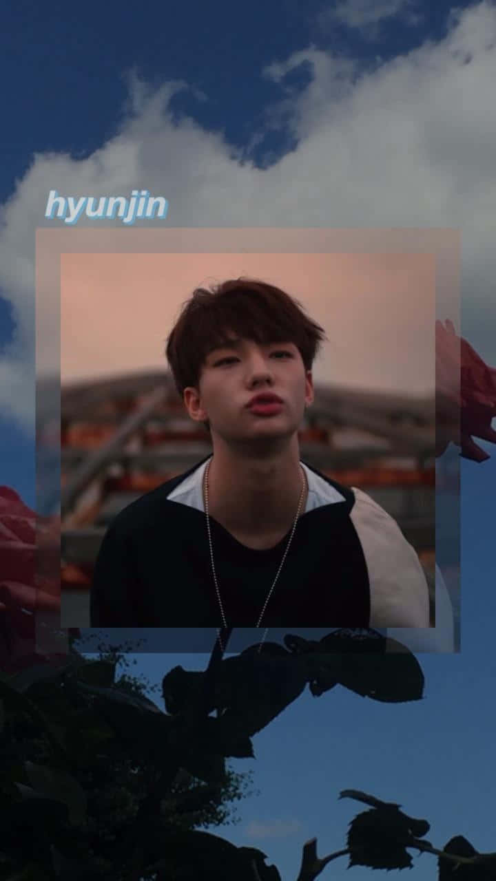 hyunjin 桌布 壁紙 — 一個年輕男子，一頭凌亂的棕色頭髮，仰望被花卉剪影和柔軟雲朵框住的暮色天空。