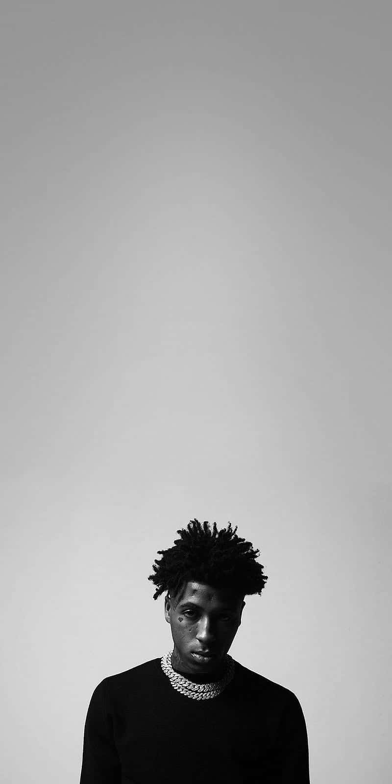 Youngboy Never Broke Again 桌布 壁紙 — 一個年輕男子的黑白肖像，他有質感的頭髮和粗鏈條項鍊，背景是純色。