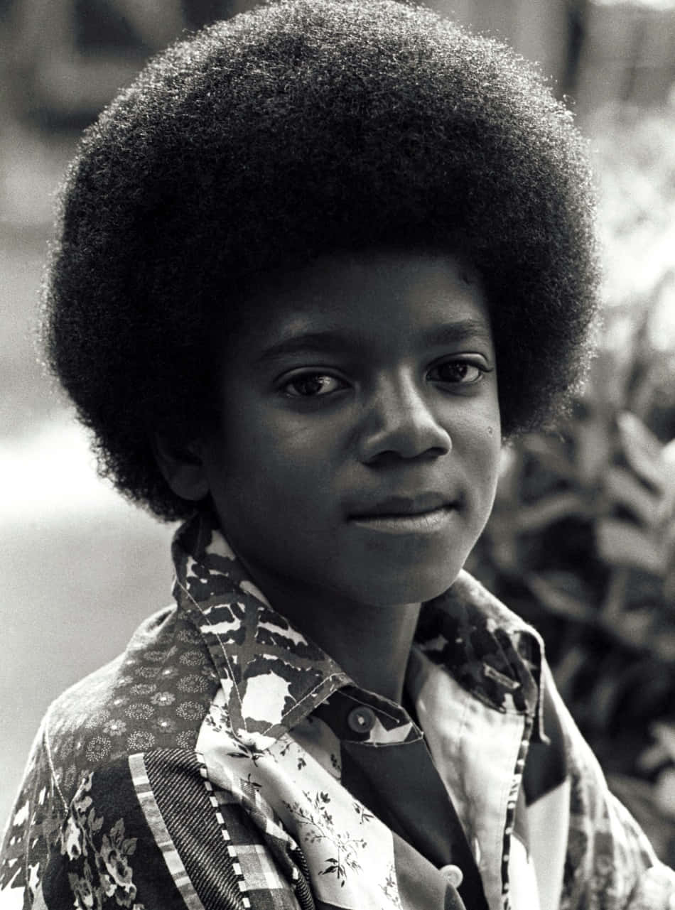 Young Michael Jackson 桌布 壁紙 — 一個年輕男孩留著大爆炸頭，在黑白肖像中若有所思地凝視鏡頭。
