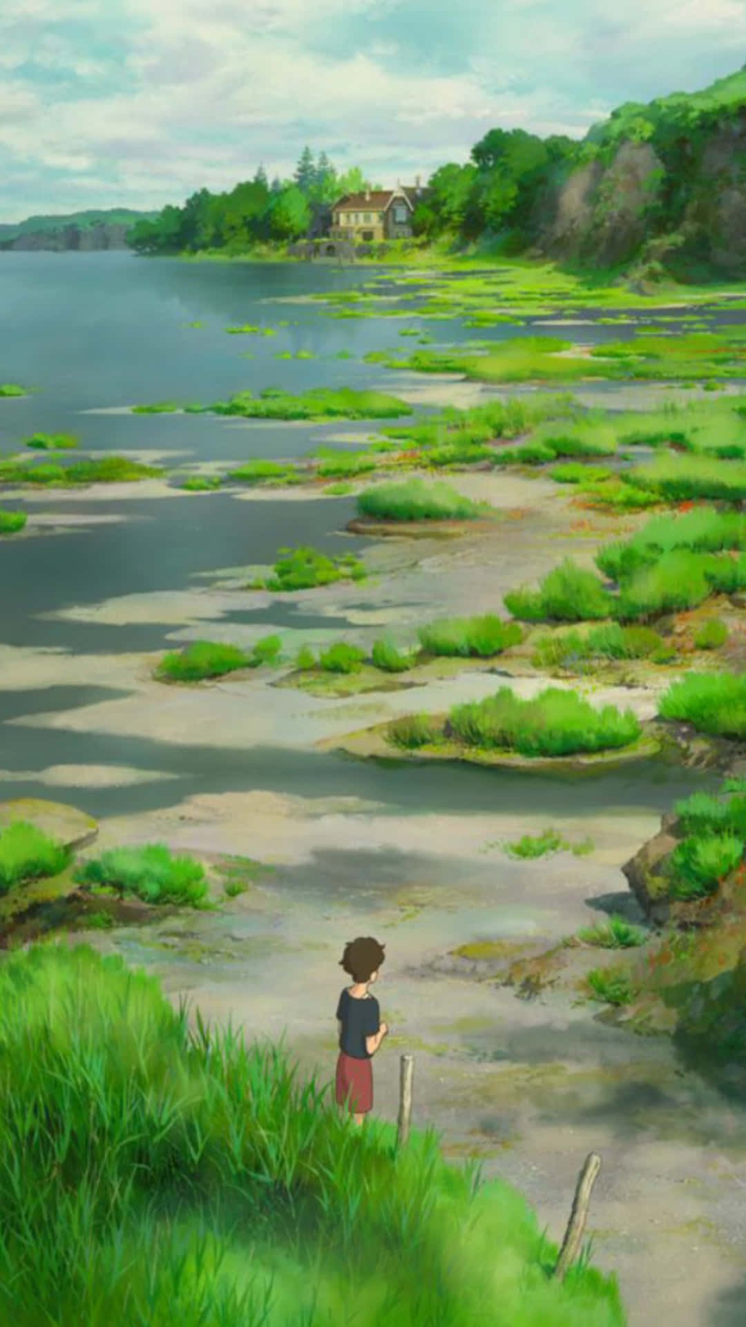 Studio Ghibli Phone 桌布 壁紙 — 一個年輕男孩站在草坡上，凝視著平靜的湖面，湖上有綠色斑點，遠處樹叢中有一座房子。