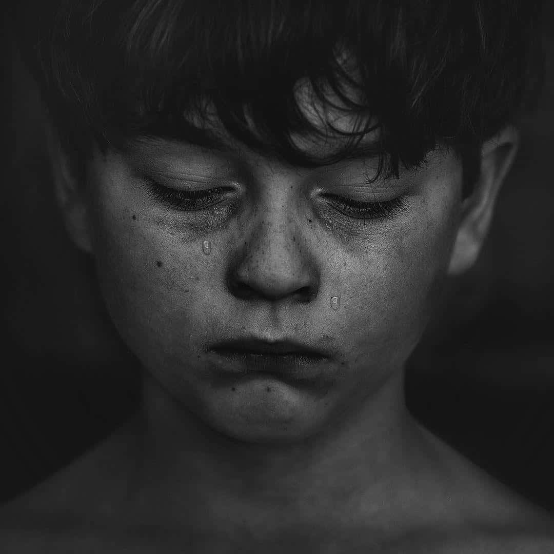 cry 桌布 壁紙 — 一個年輕男孩閉上眼睛，淚水順著臉頰流下的黑白特寫。