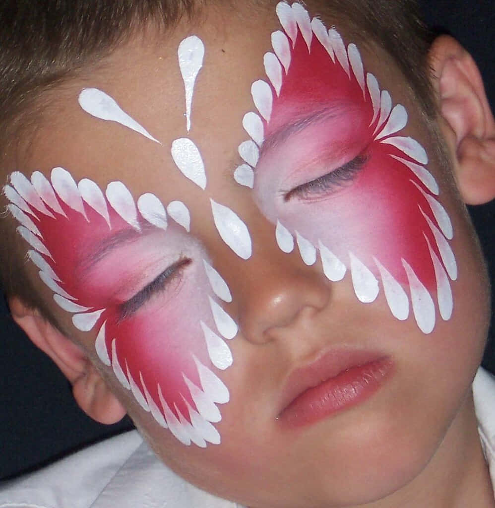Butterfly Face Painting 桌布 壁紙 — 一個年輕男孩閉上眼睛，臉頰和額頭上塗著鮮豔的紅白蝴蝶臉部彩繪。